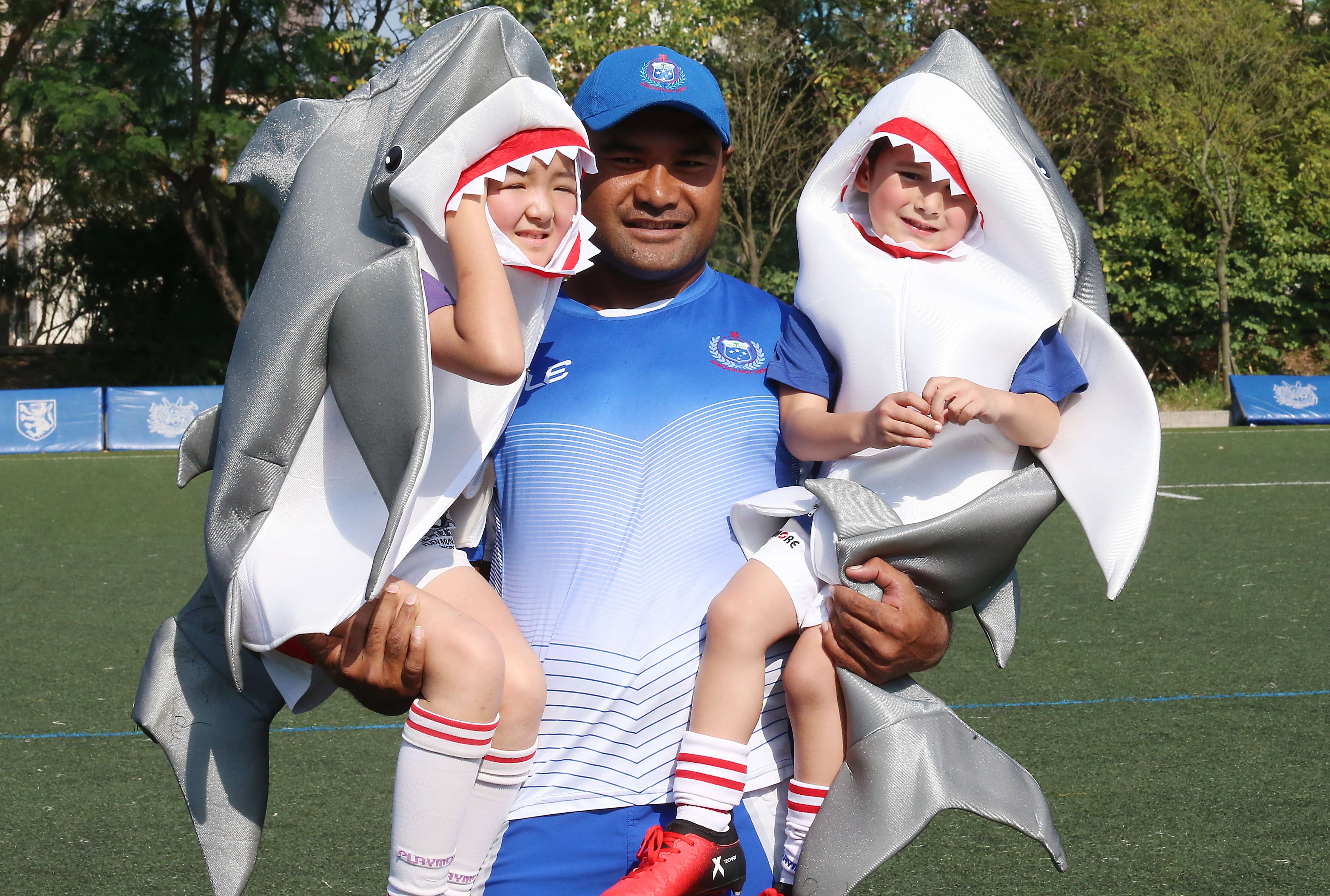 Captain Faalemiga Selesele of Samoa and kids of Tuen Mun Sharks mini rugby club dress up as sharks to raise awareness of shark conservation. Photo: K. Y. Cheng