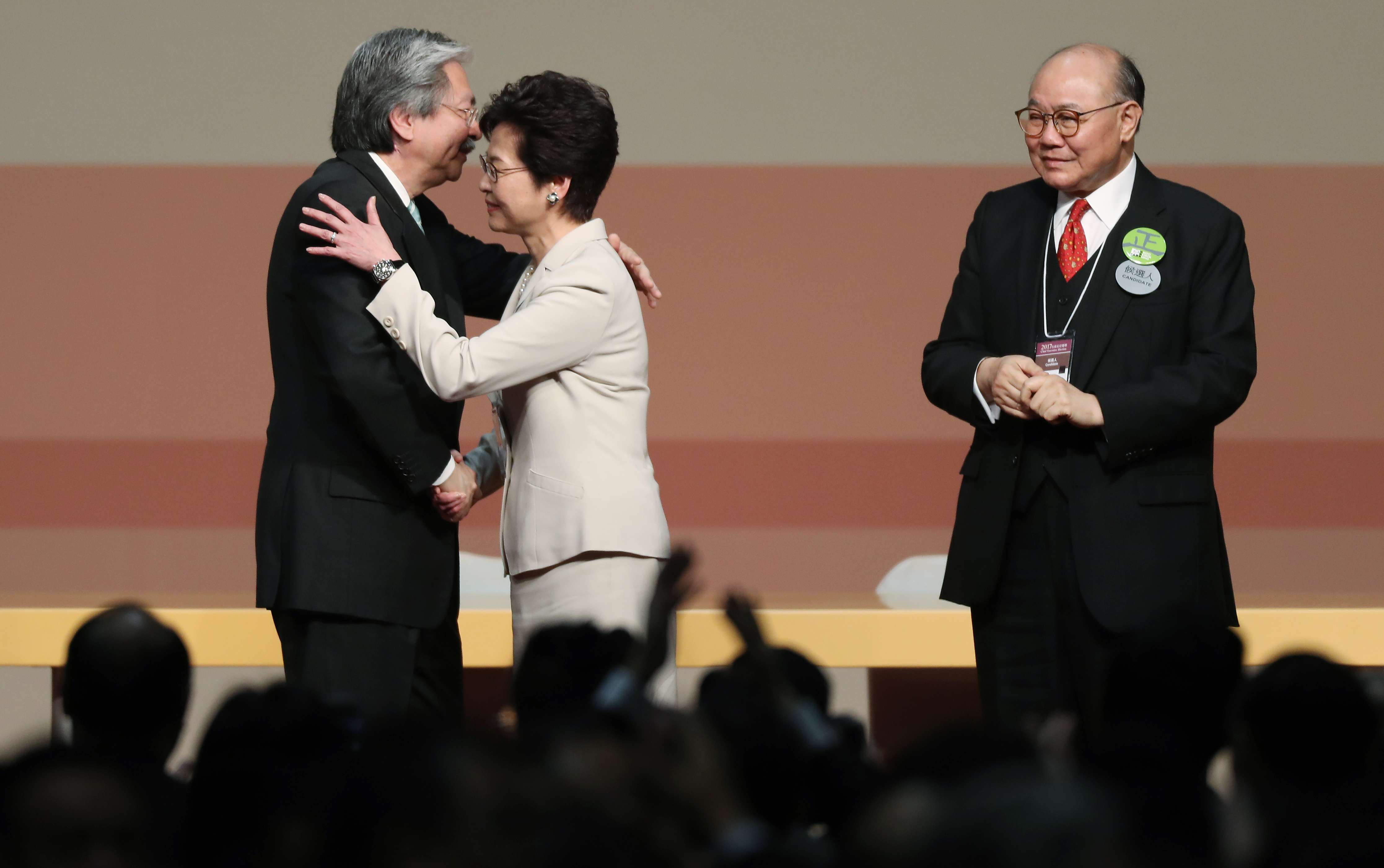 Chief executive election candidates John Tsang Chun-wah (left) and Carrie Lam Yuet-ngor (centre) embrace as fellow candidate Woo Kwok-hing looks on during the announcement of the results. Photo: Robert Ng