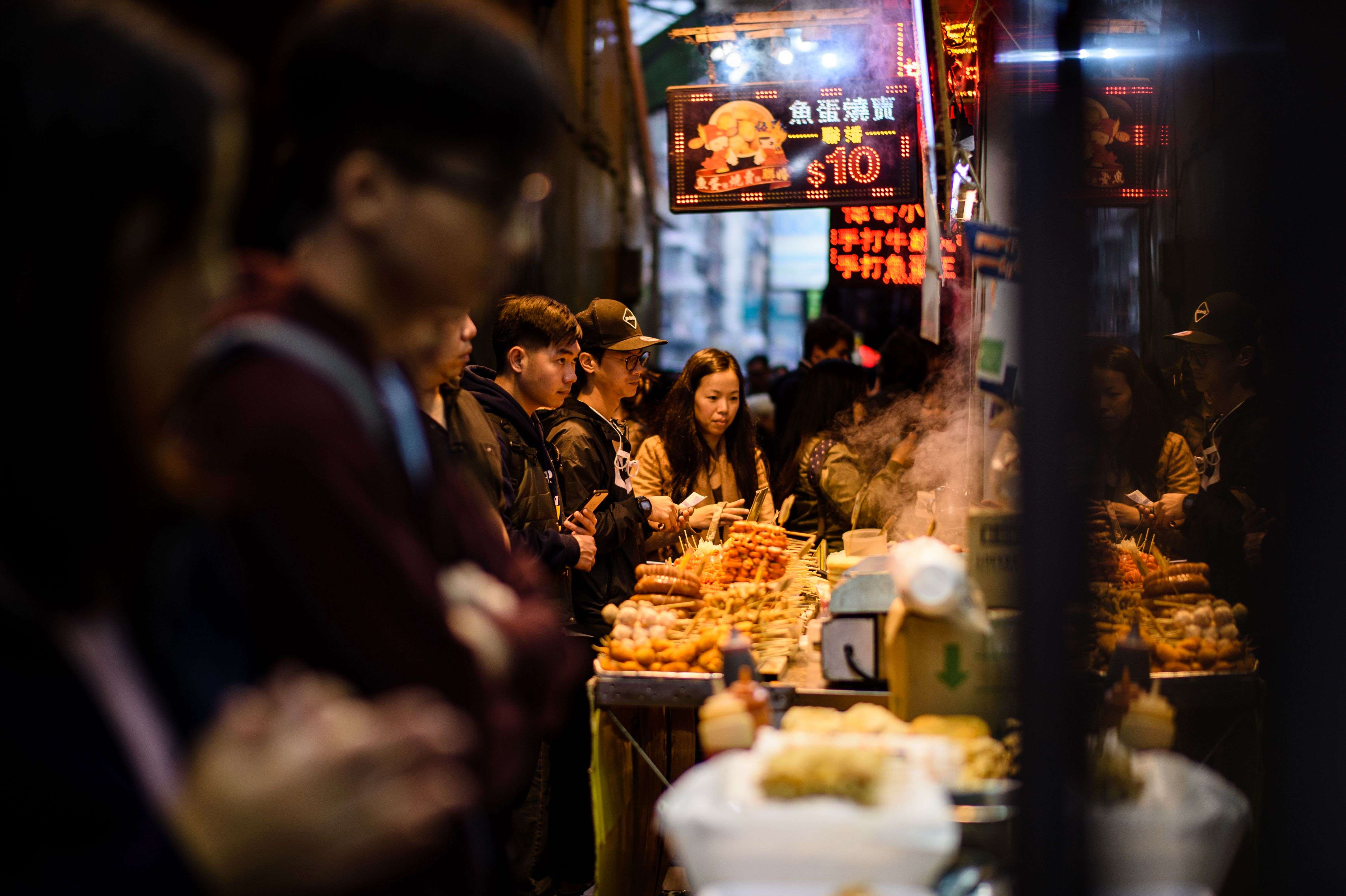 Customers queue to buy snacks being sold by food vendors. Photo: AFP Photo