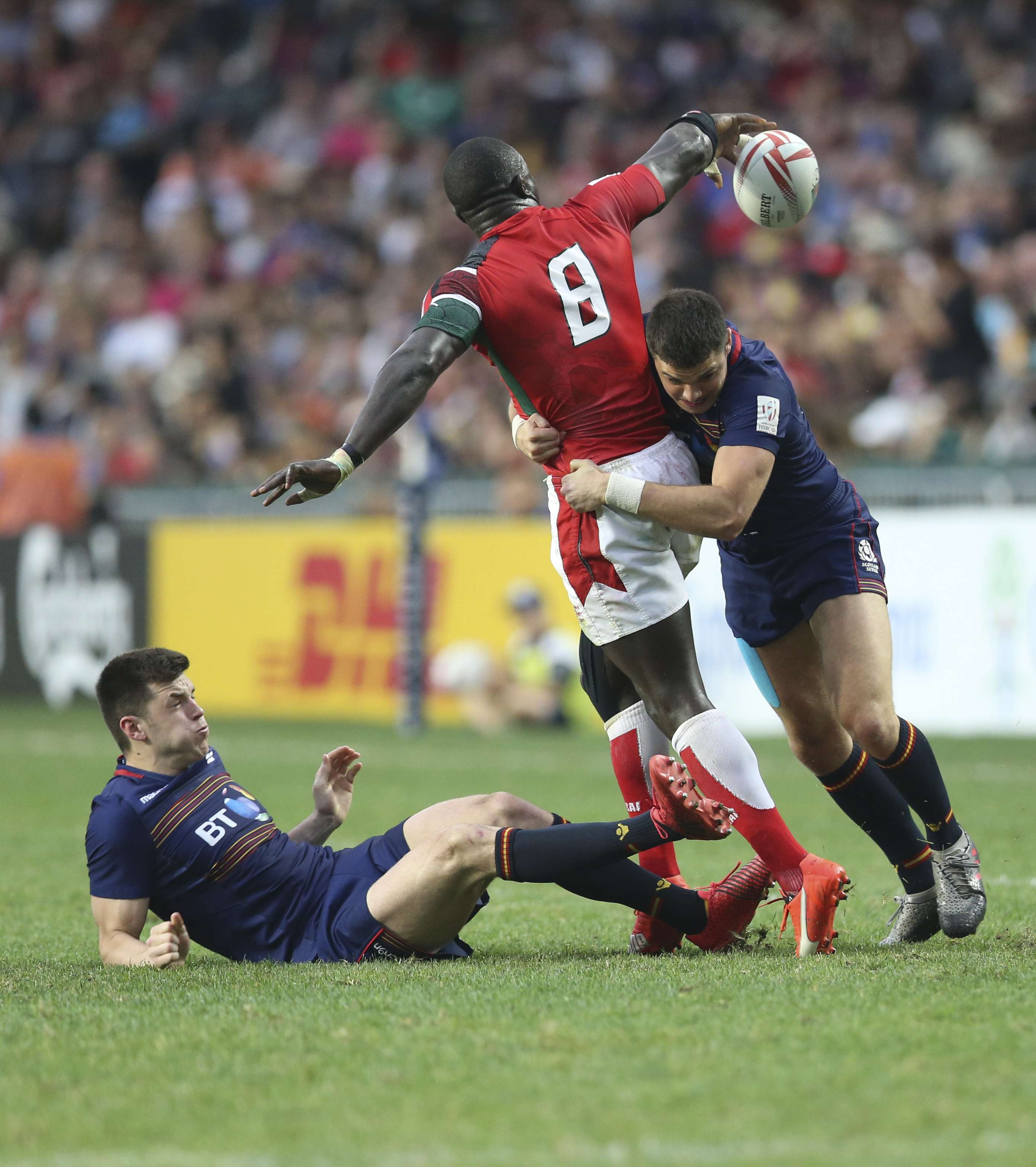 Kenya’s Andrew Amonde is tackled by Bobby Beattie from Scotland in the Bowl final. Photo: Dickson Lee