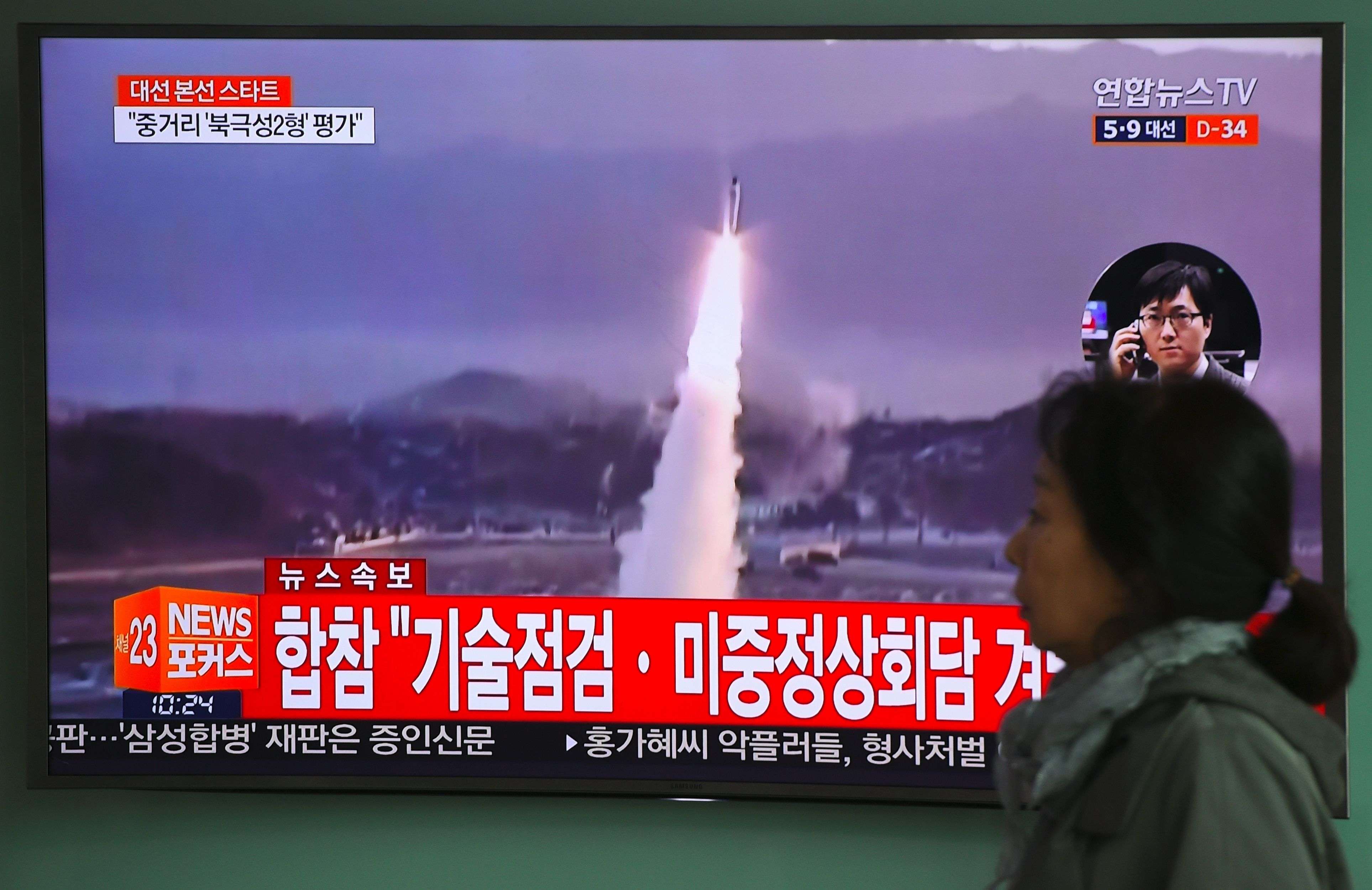 A woman walks past a television screen in Seoul, South Korea, showing file footage of a North Korean missile launch on Wednesday. The North fired a ballistic missile into the Sea of Japan that day, just ahead of the China-US summit in Florida. Photo: AFP