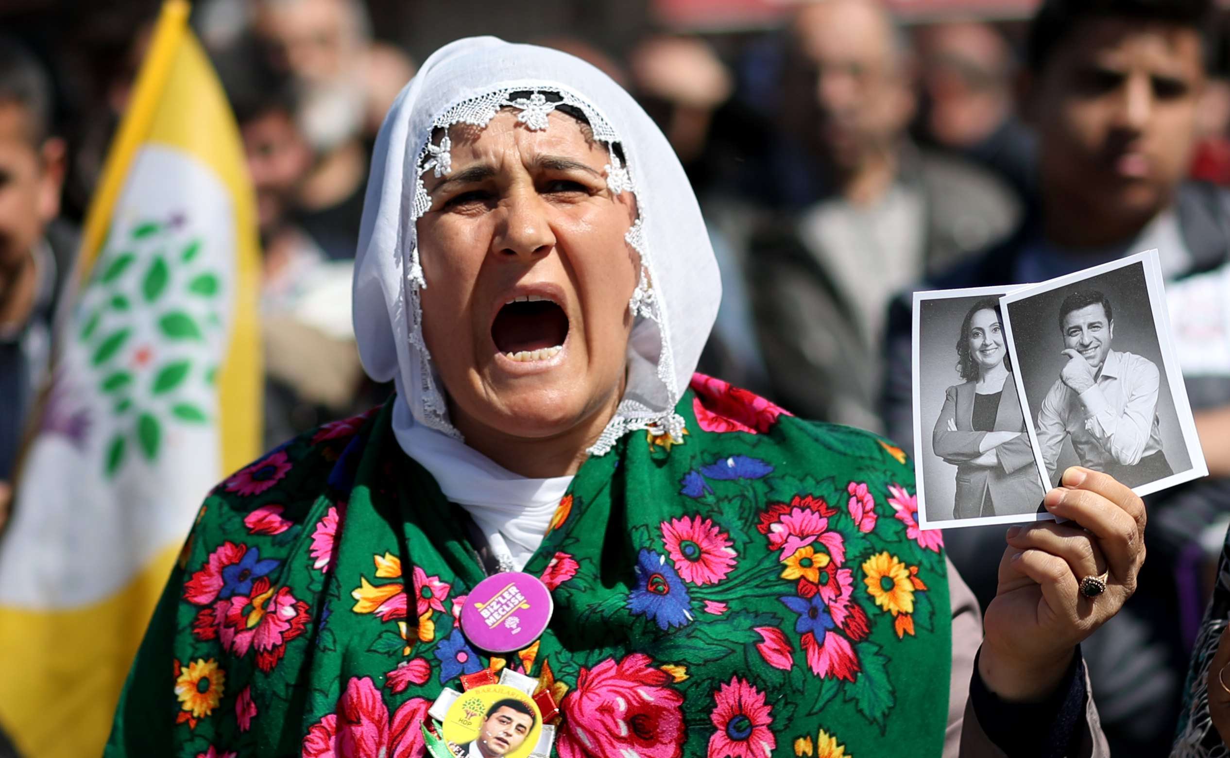 A supporter of the pro-Kurdish People’s Democratic Party holds pictures of party co-leaders who were arrested as part of a terror investigation, during a “Vote No” rally in Istanbul on April 13. Photo: EPA
