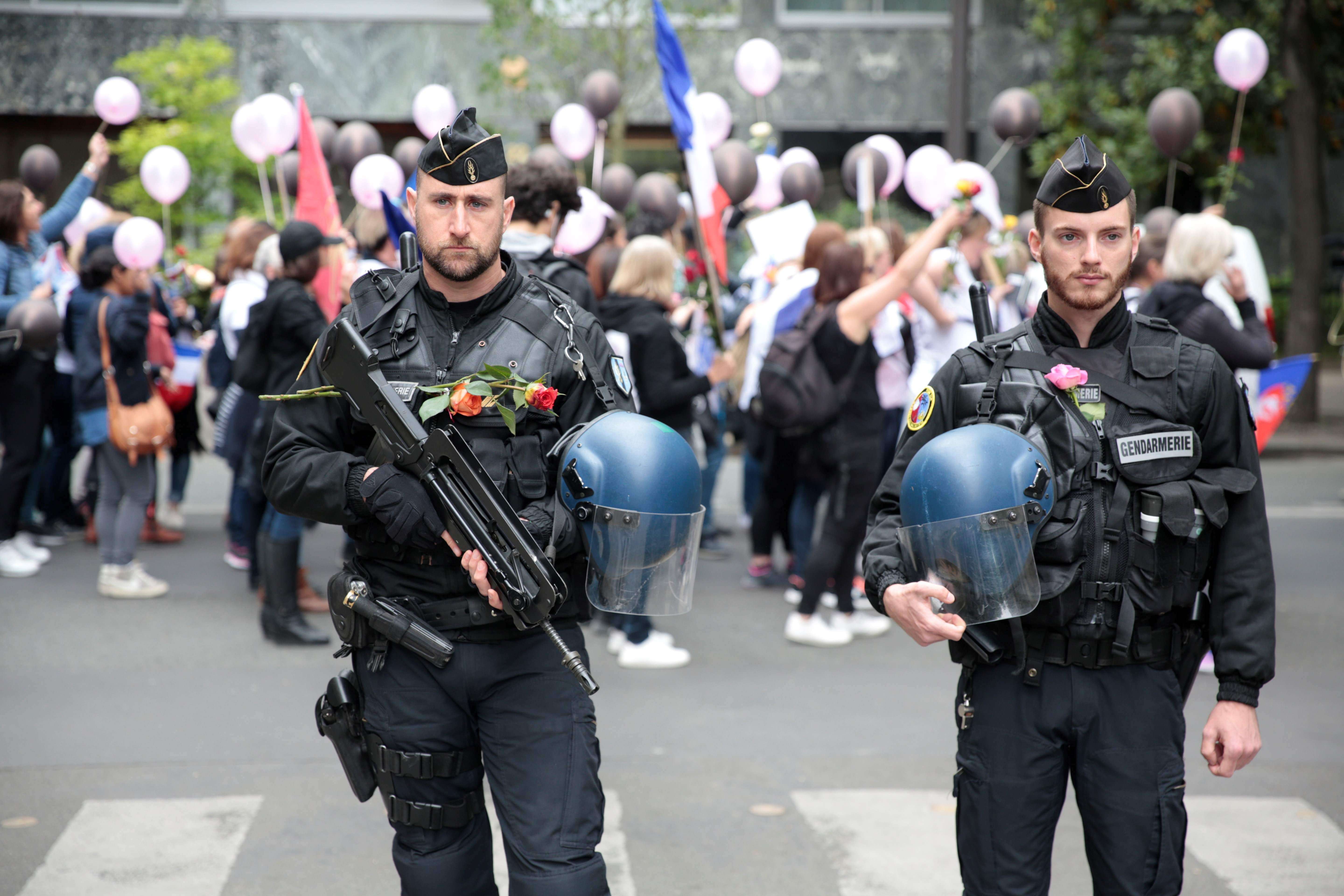 Policemen bearing flowers stand during a rally organized by the “Angry Policemen's Wife” (FFOC) in support of French policemen, near the esplanade of the Champs de Mars. Photo: AFP