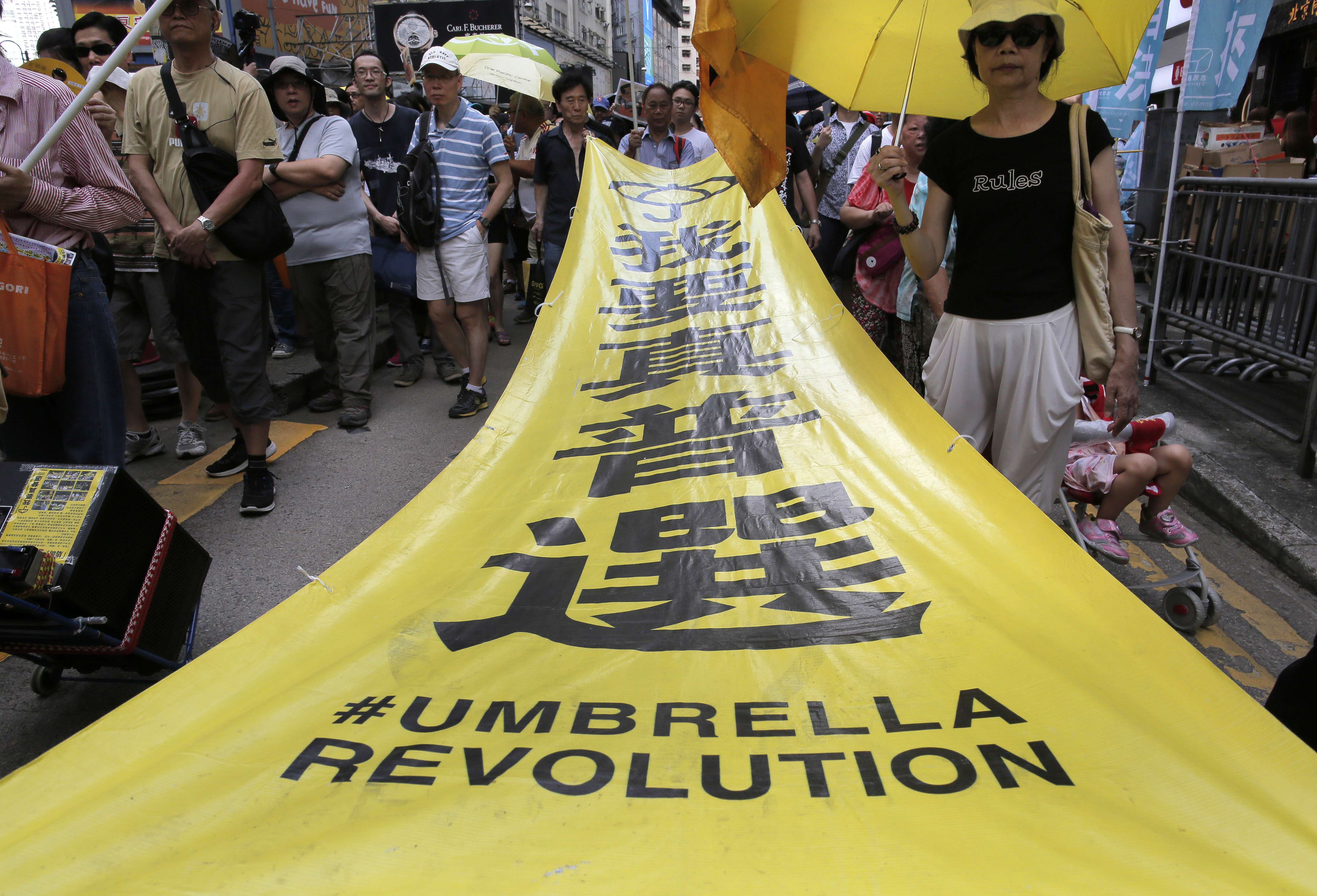 Demonstrators taking part in Hong Kong’s annual pro-democracy march carry a banner saying “I want genuine universal suffrage”, above the hashtag “Umbrella Revolution”, last July 1. Photo: AP
