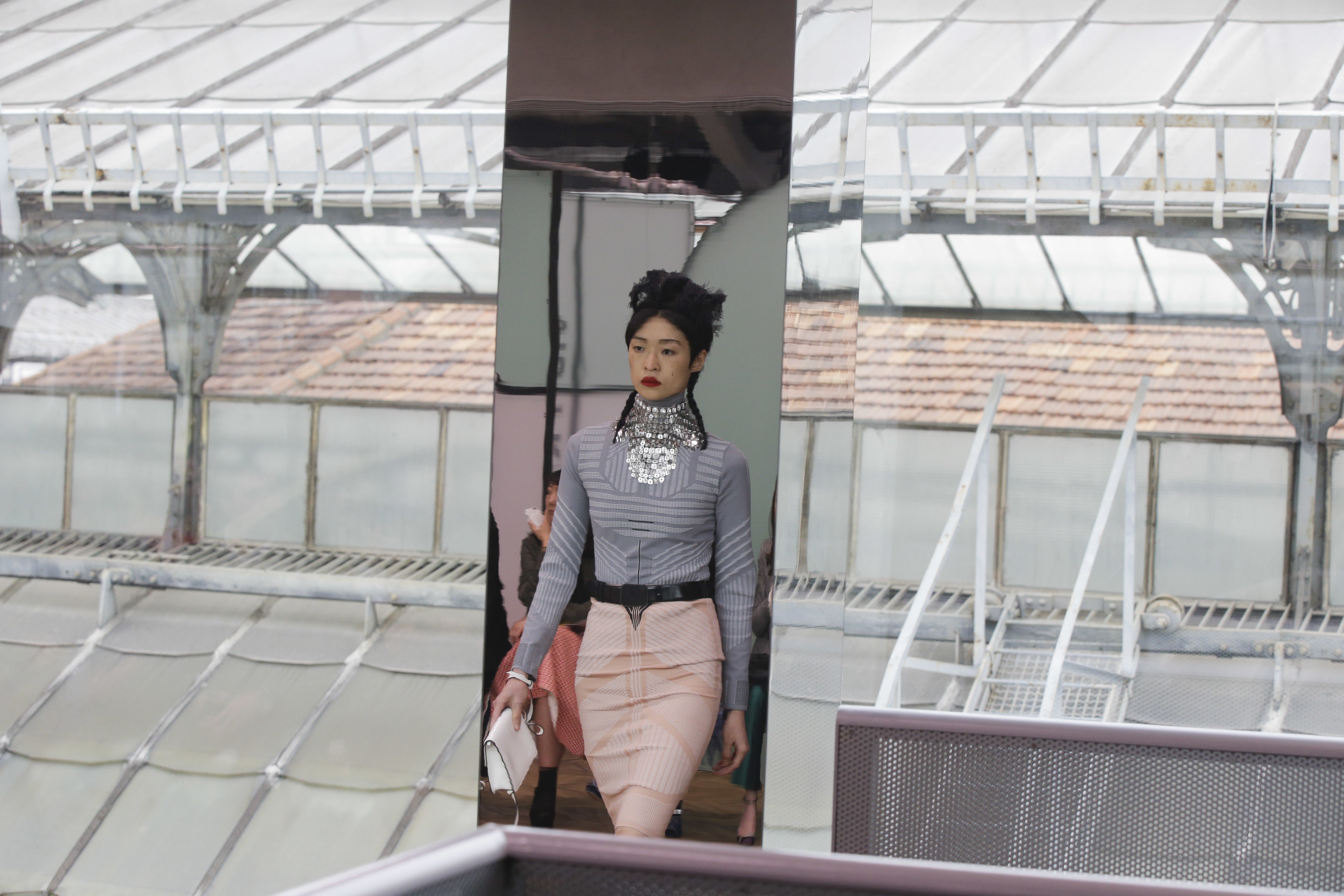 A model reflected in a mirror wears a creation part of the women's Prada Cruise mid season collection, first ever runway show. Photo: AP