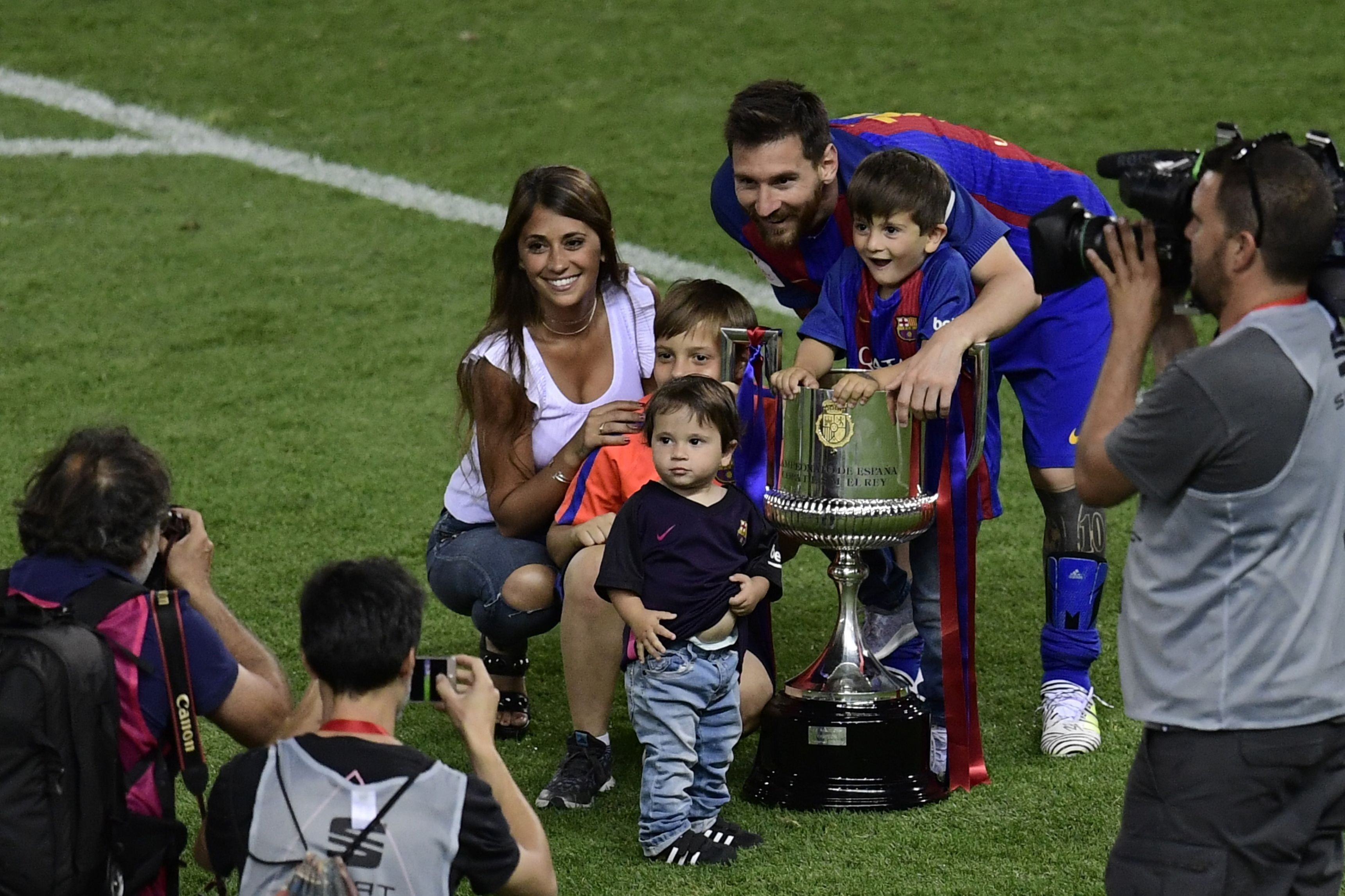 Barcelona's Argentinian forward Lionel Messi (C), his wife Antonella Roccuzzo and sons pose with the trophy at the end of the Spanish Copa del Rey (King's Cup) final football match FC Barcelona vs Deportivo Alaves at the Vicente Calderon stadium in Madrid on May 27, 2017. Barcelona won 3-1. / AFP PHOTO / JAVIER SORIANO