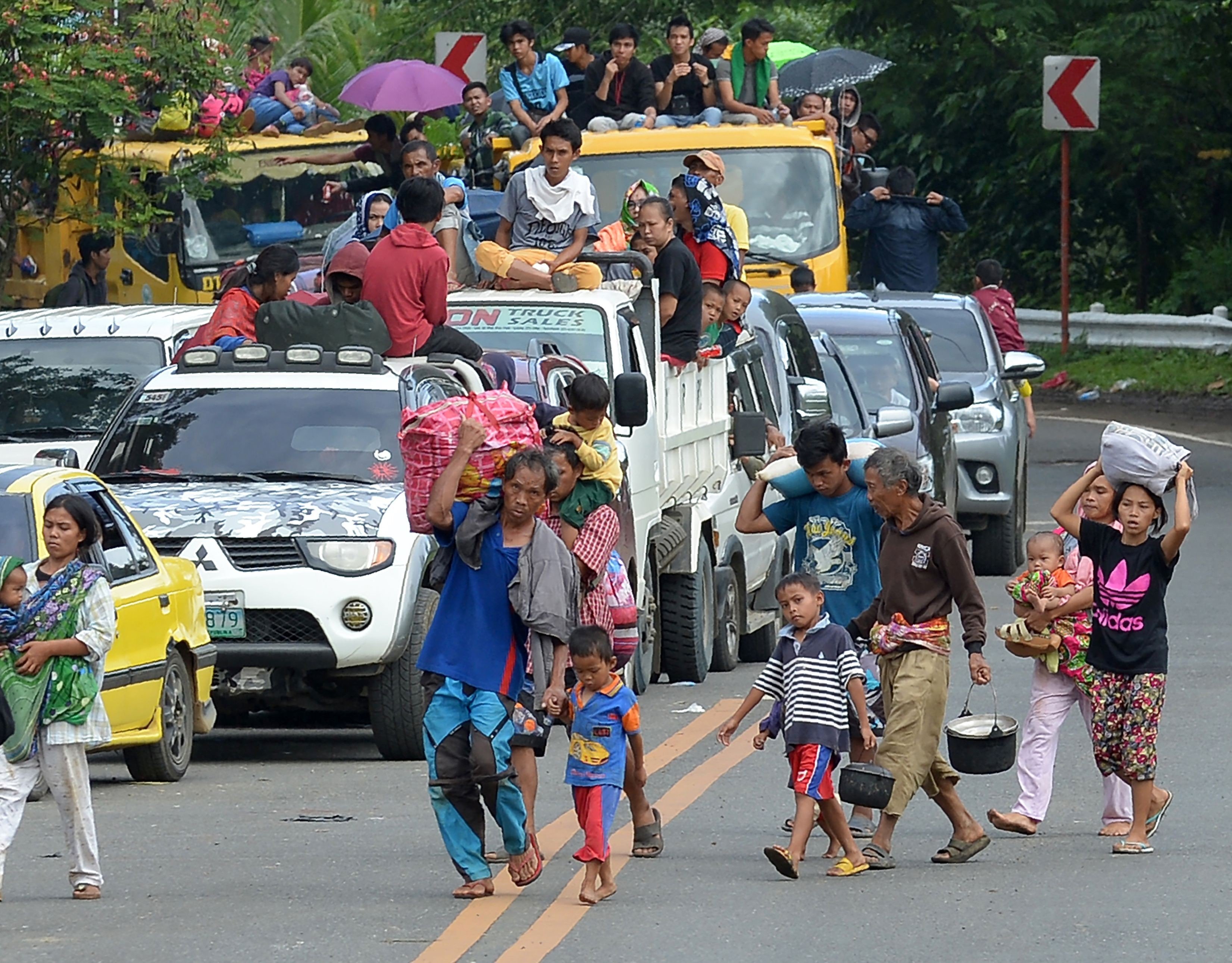 Families carrying their belongings flee Marawi city, in the southern mainly Muslim island of Mindanao, on May 26, amid fighting between Islamist militants and government forces. Photo: AFP