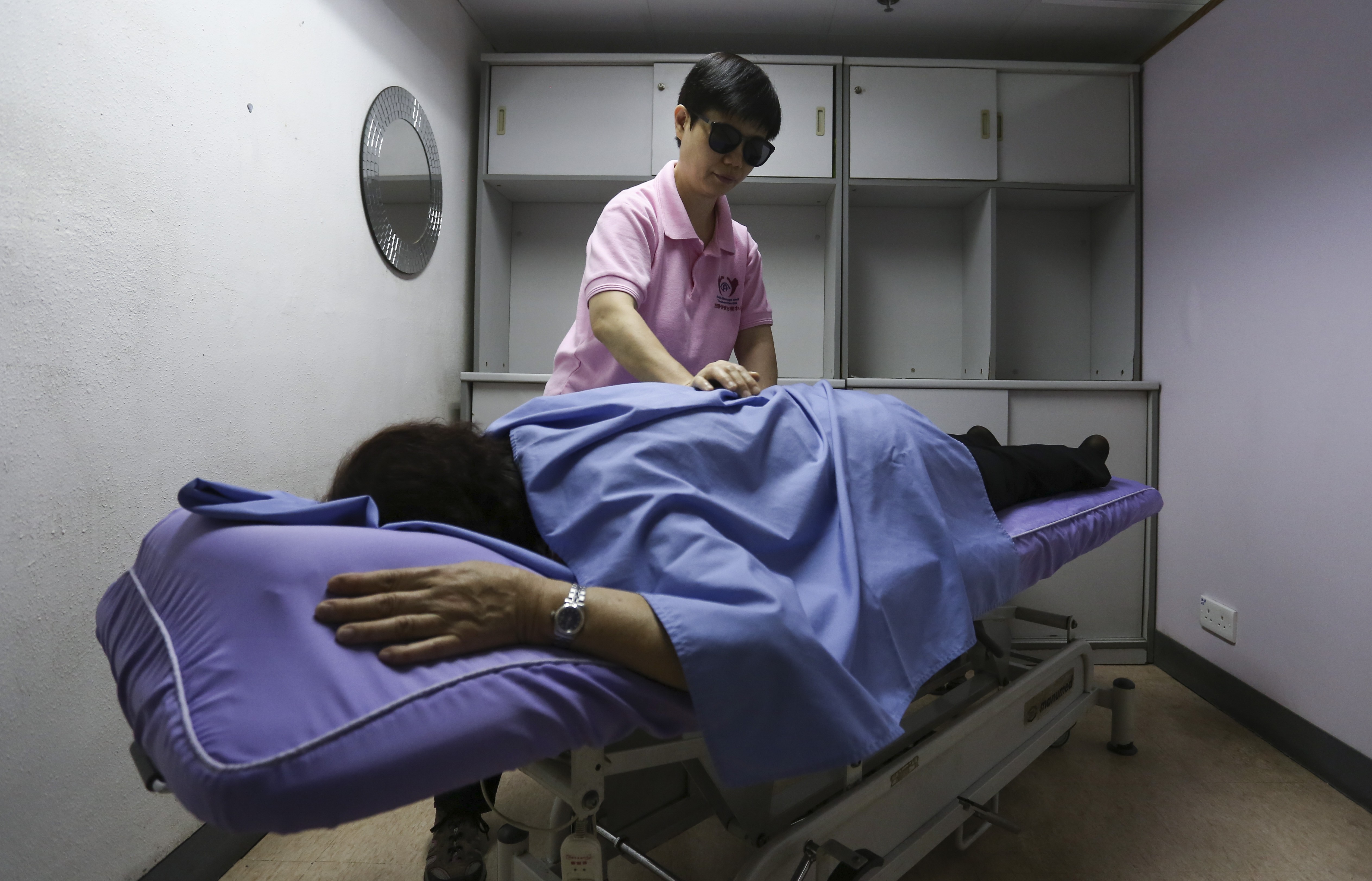 Masseuse Chan Chat-fung gives a massage to a client in Shek Kip Mei. Photo: Jonathan Wong