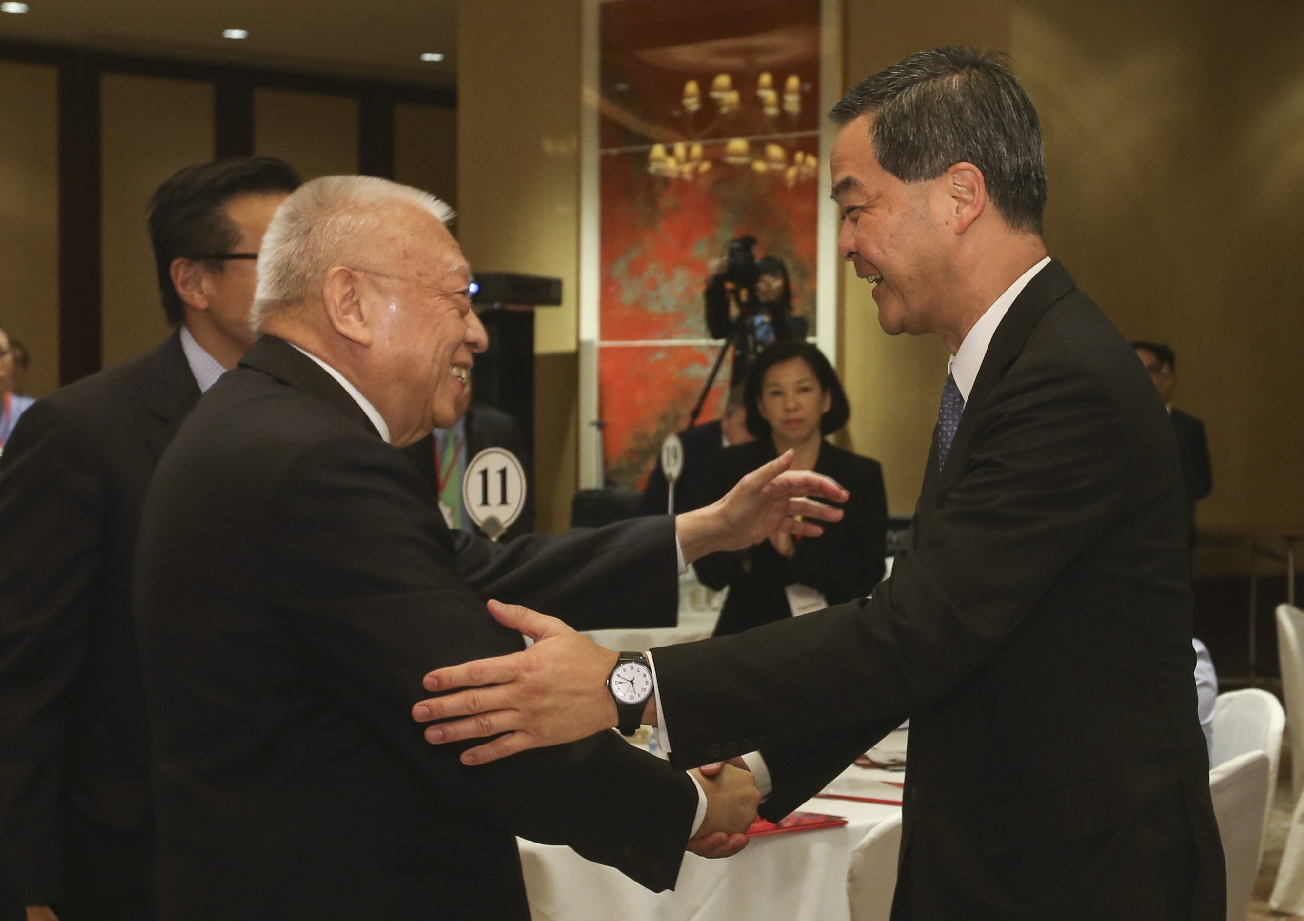 Former Hong Kong chief executive Tung Chee-hwa (left) shaking hands with incumbent chief executive Leung Chun-ying at the forum at the Conrad Hotel in Admiralty on Monday. Photo: K. Y. Cheng