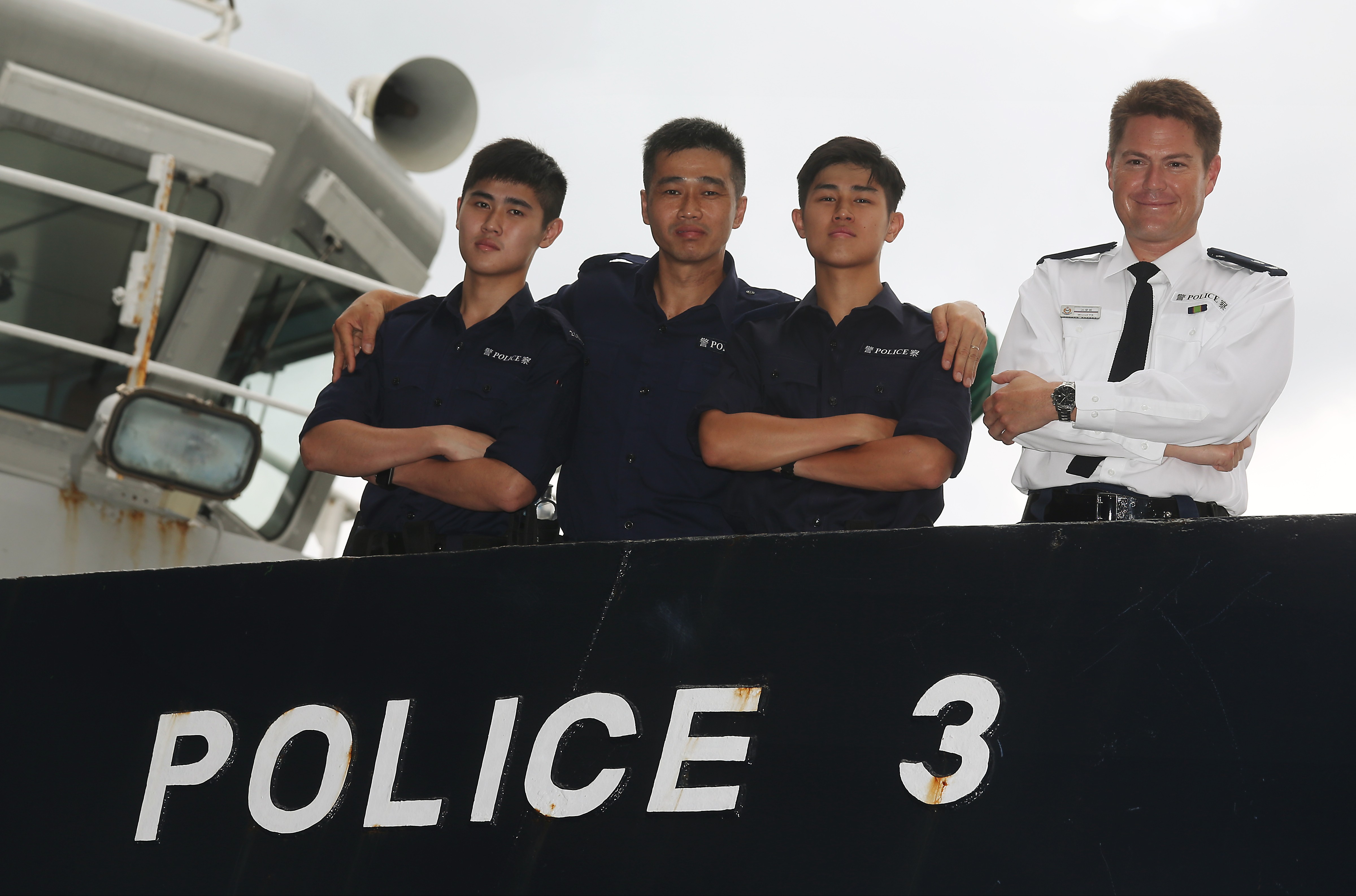 Marine police officers Lam Ho-long (left), father Lan Cheuk-lun, Lam Ho-chun and Tim Worrall (right) on a boat at headquarters in Sai Wan Ho. Photo: K. Y. Cheng