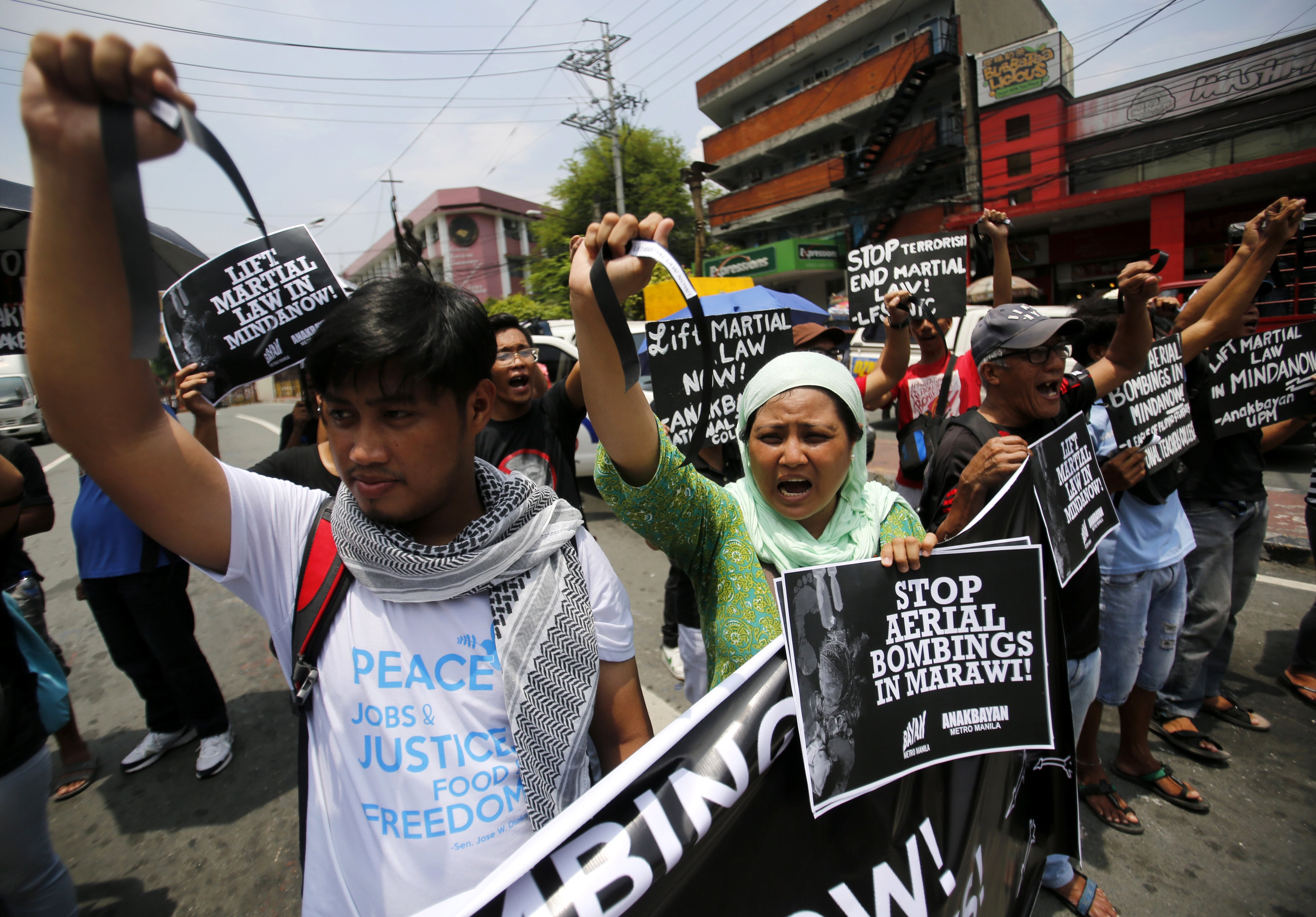 Protesters stage a demonstration dubbed “Black Friday” to mark the first month of the declaration of martial law in Mindanao, near the presidential palace in Manila on June 23. Photo: EPA