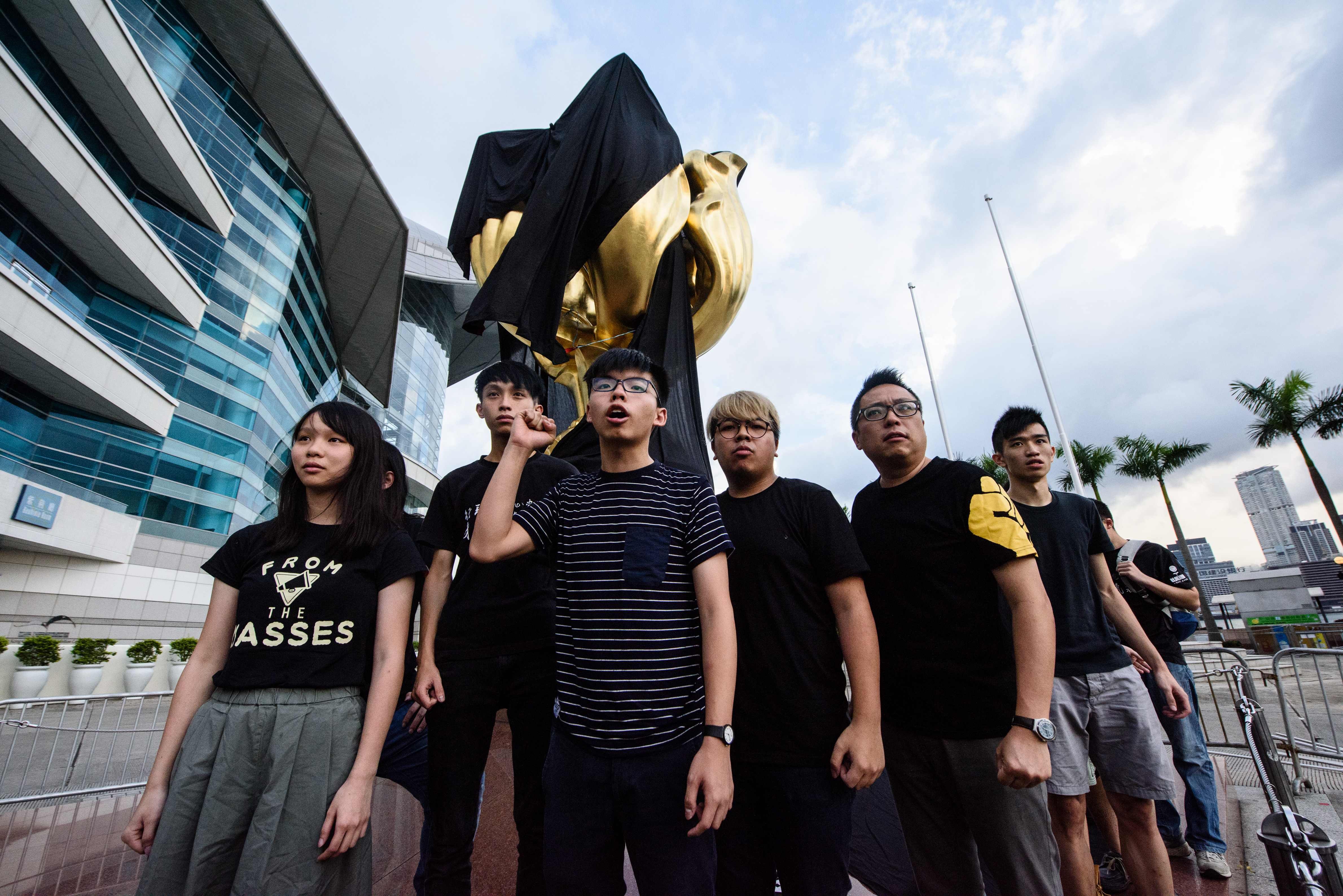 Joshua Wong and other Demosisto party members shout slogans after draping a black cloth on the Golden Bauhinia statue, on June 26. Protests such as these are likely to be interpreted by Beijing both as an objection to Hong Kong being restored to China, and as a deliberate, calculated insult to the president. Photo: AFP