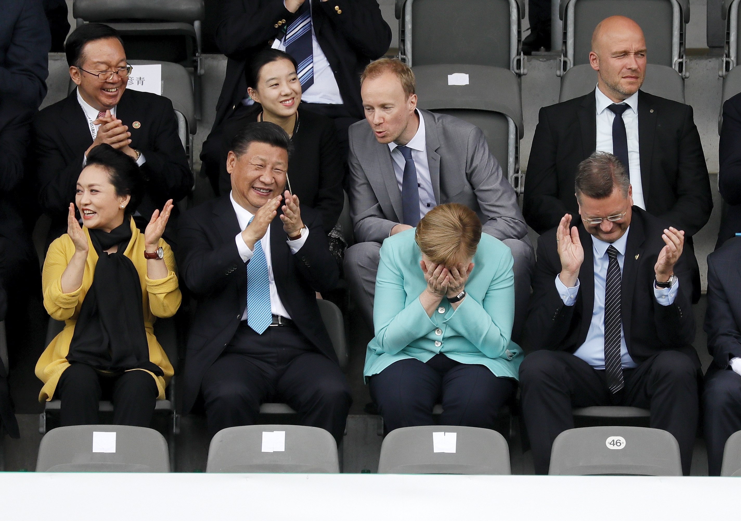 Xi Jinping cracks an unusually large grin as he watches the Germany-China under-12 match with his wife Peng Liyuan and German chancellor Angela Merkel. Photo: EPA
