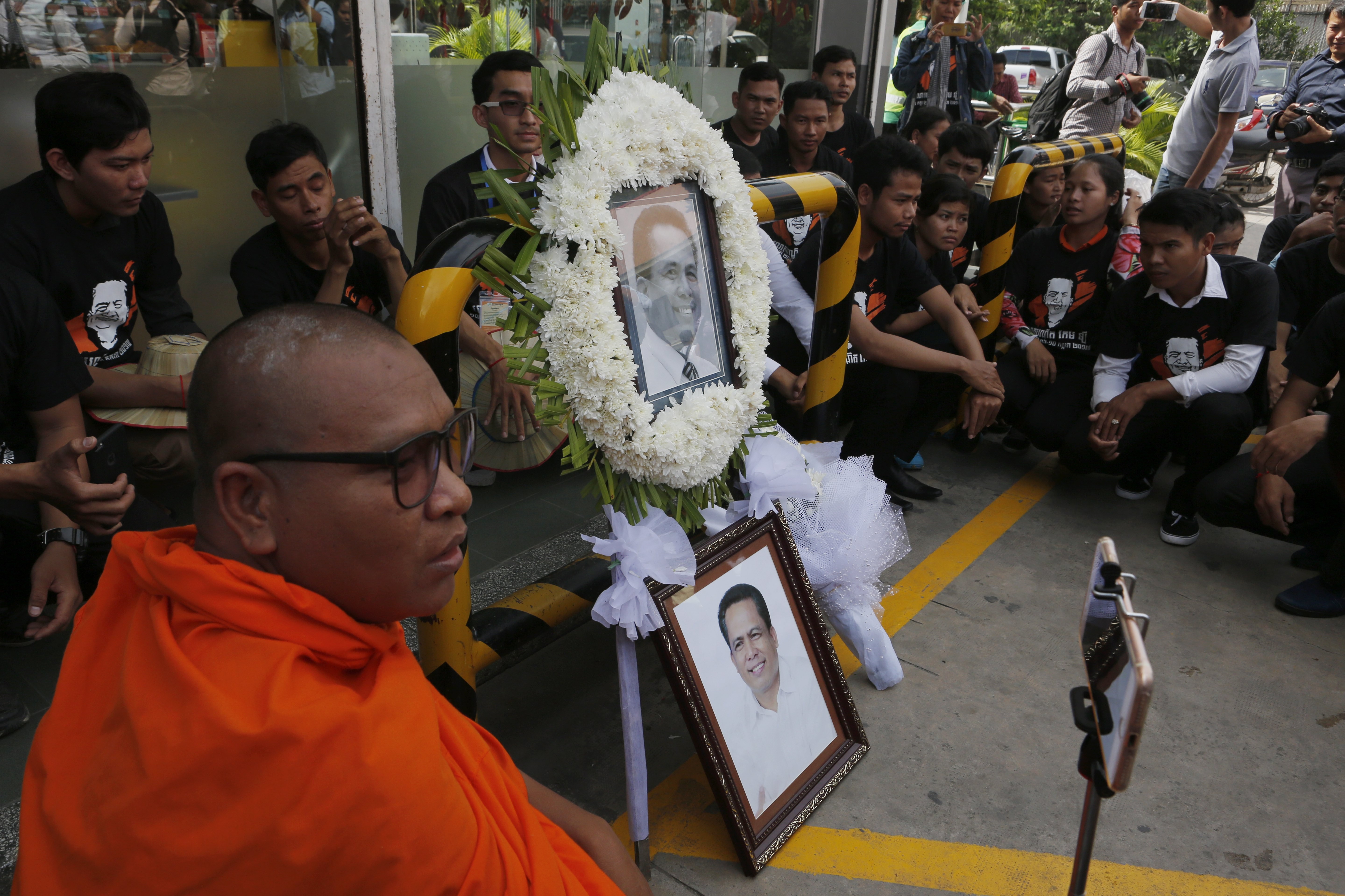 A Cambodian monk takes a selfie with portraits of independent political analyst Kem Ley during a ceremony in Phnom Penh on Monday, when supporters marked Kem Ley's one-year death anniversary. The Cambodian political commentator and activist was shot dead at a Star Mart Caltex gas station in Phnom Penh on 10 July 2016. Photo: EPA