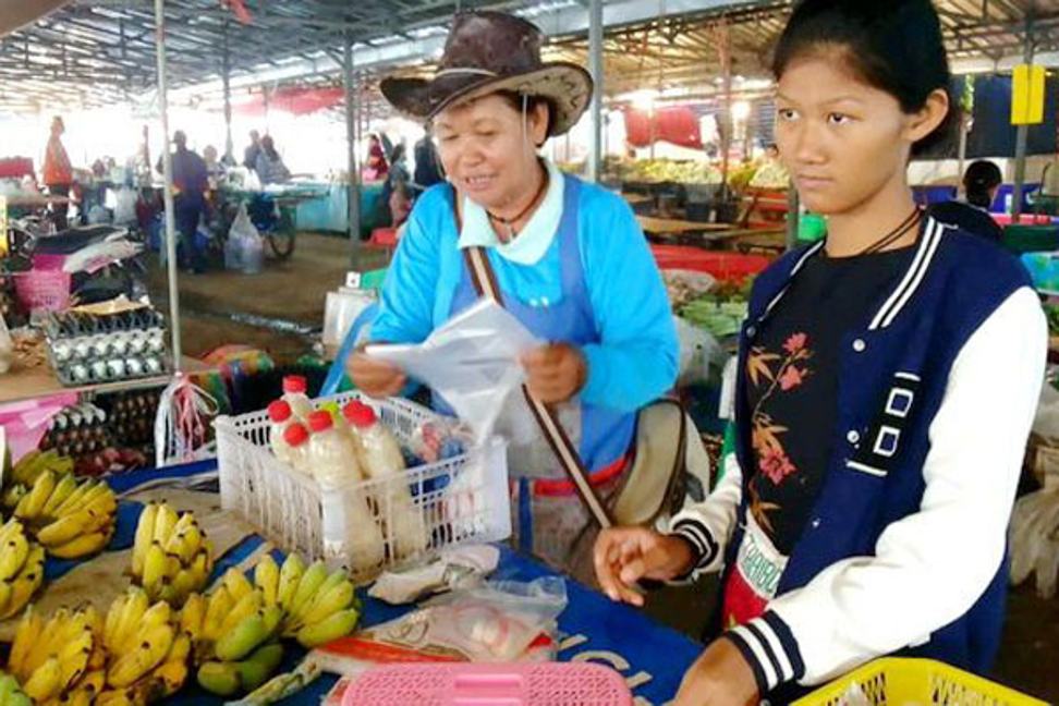 Ann helps her grandmother at the local food market. Photo: Bangkok Post