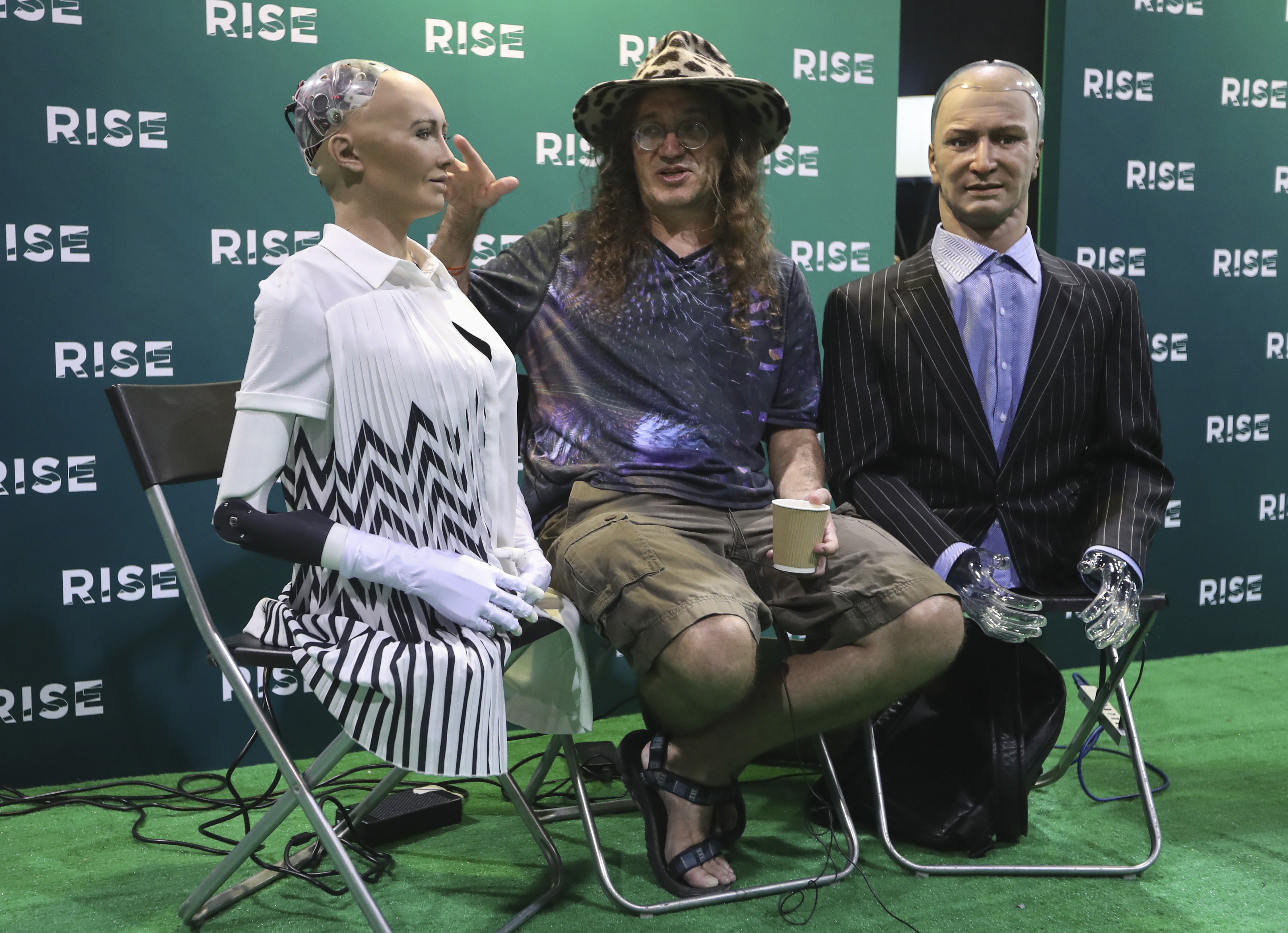 Companies should have a strategy to create an open AI culture to foster human and machine relationships. Scientist Ben Goertzel (centre) displays robots he created at the Rise conference in Hong Kong. Photo: Nora Tam