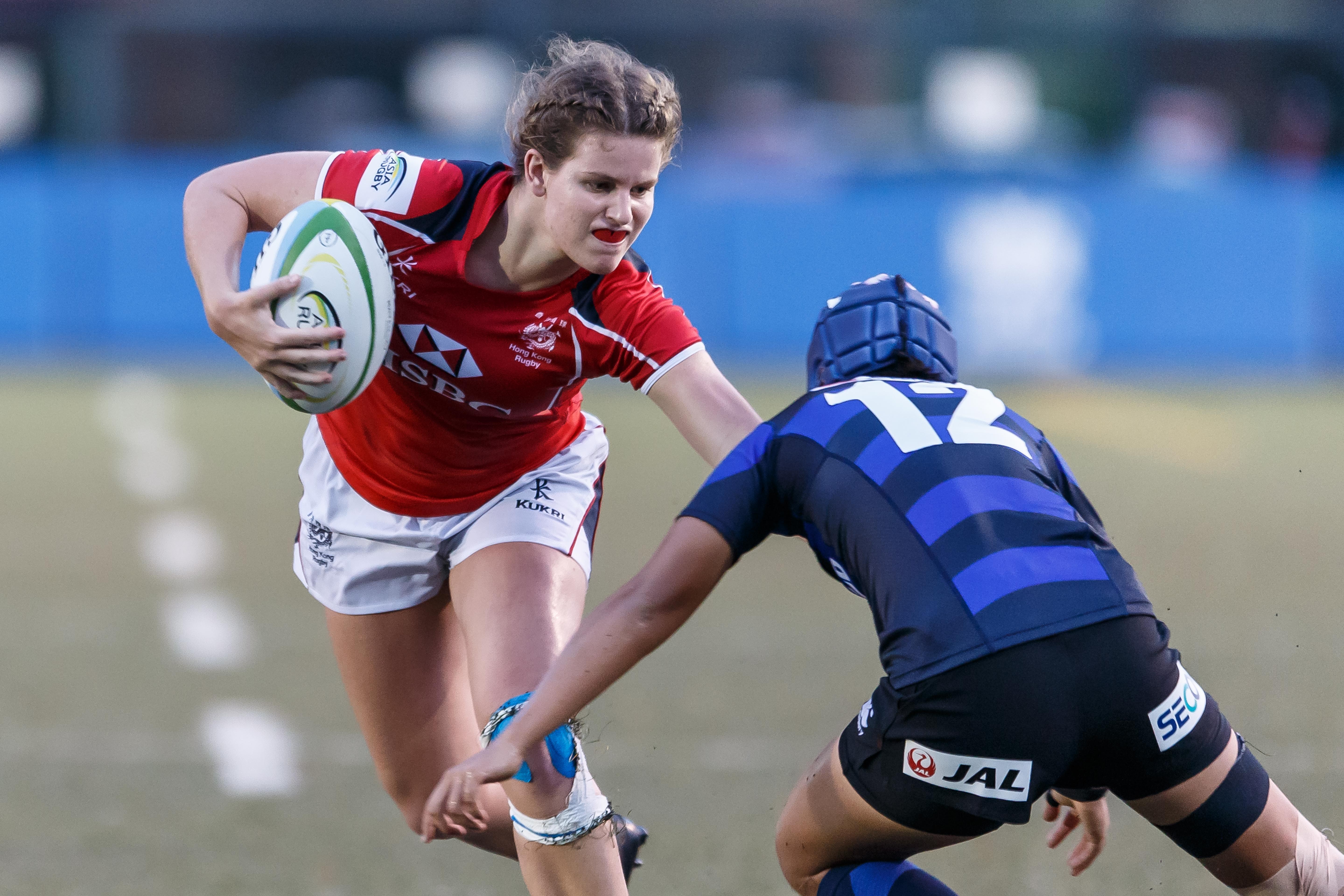 Hong Kong youngster Kelsie Bouttle fends off her opponent in her side’s loss to Japan. Photos: HKRU
