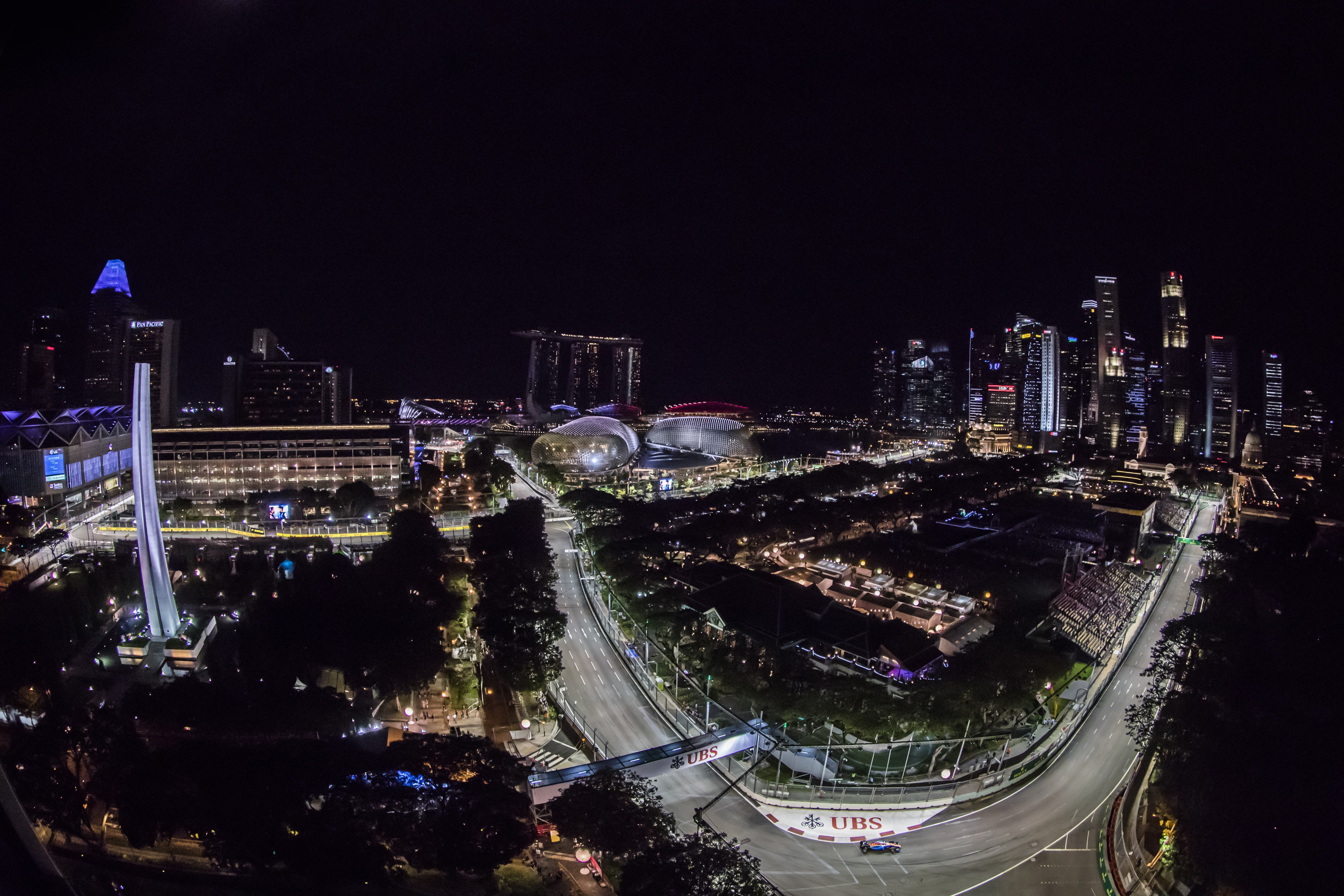 The Formula One Singapore Grand Prix dominates the night sky, with a view of Padang and Turn 9 at Marina Bay Street Circuit.