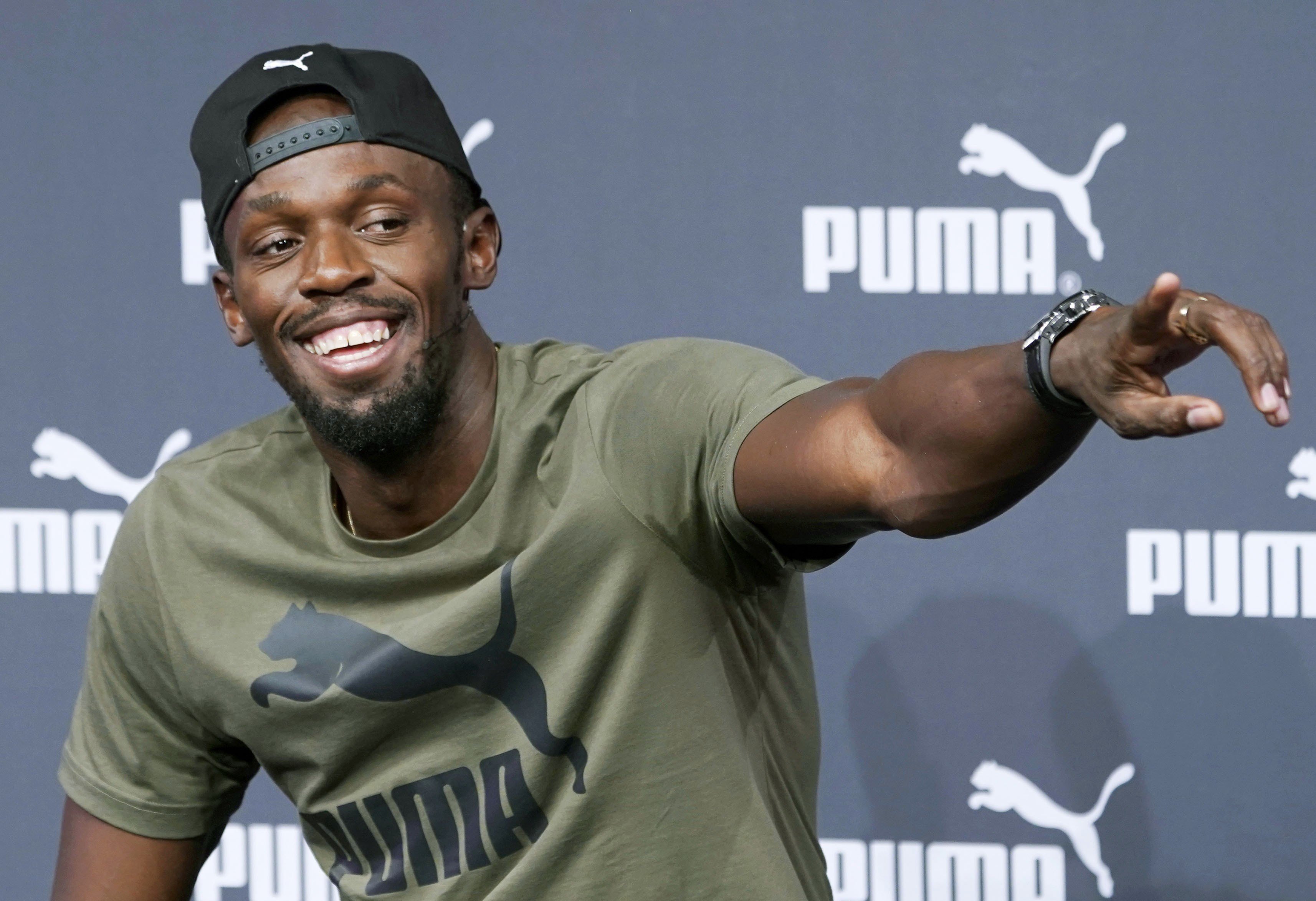 Usain Bolt points at a reporter to accept a question during a press conference in London. Photo: Kyodo