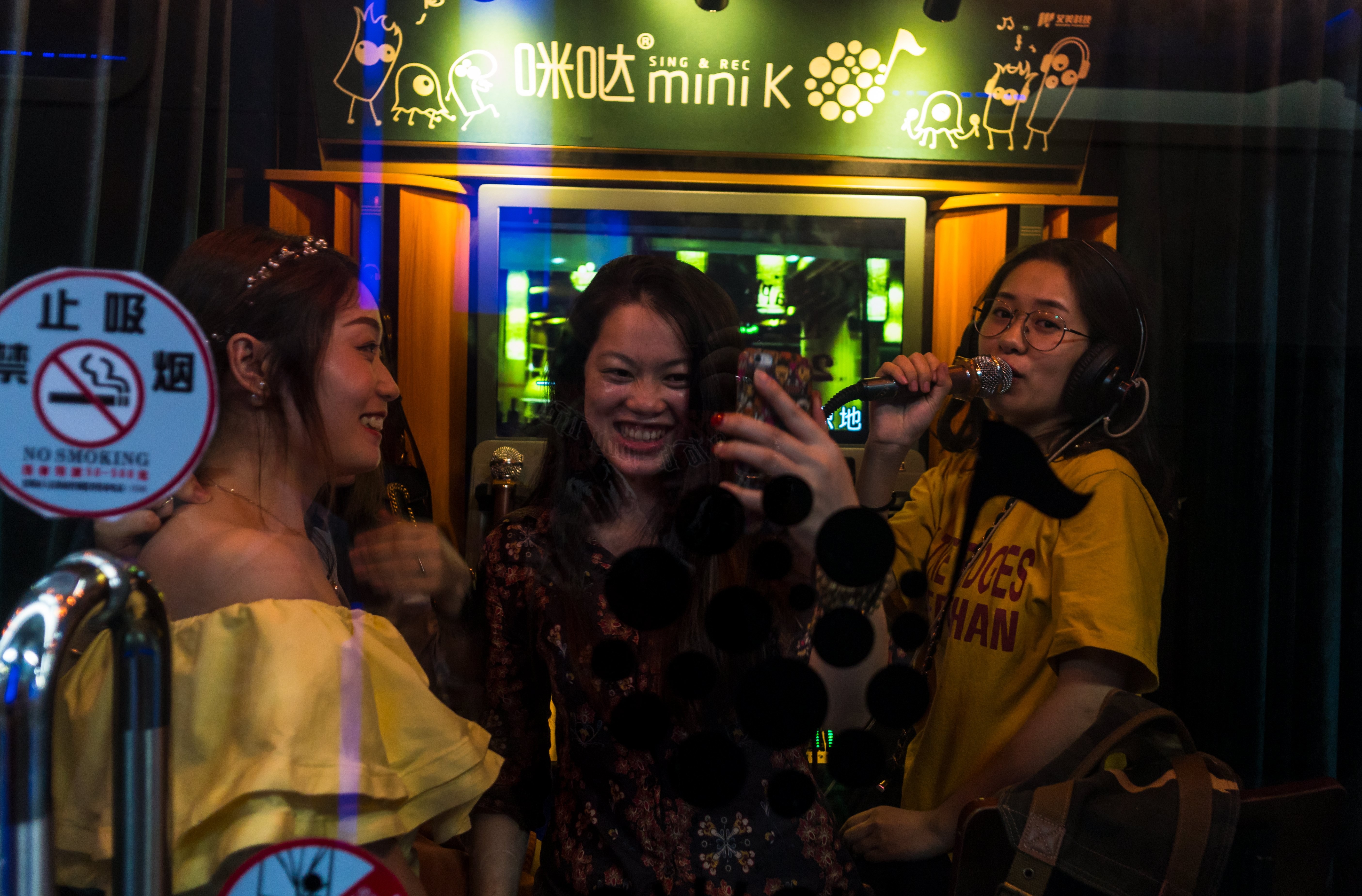 Three women enjoying a sing-song at a karaoke booth in Shenzhen. Photo: EPA