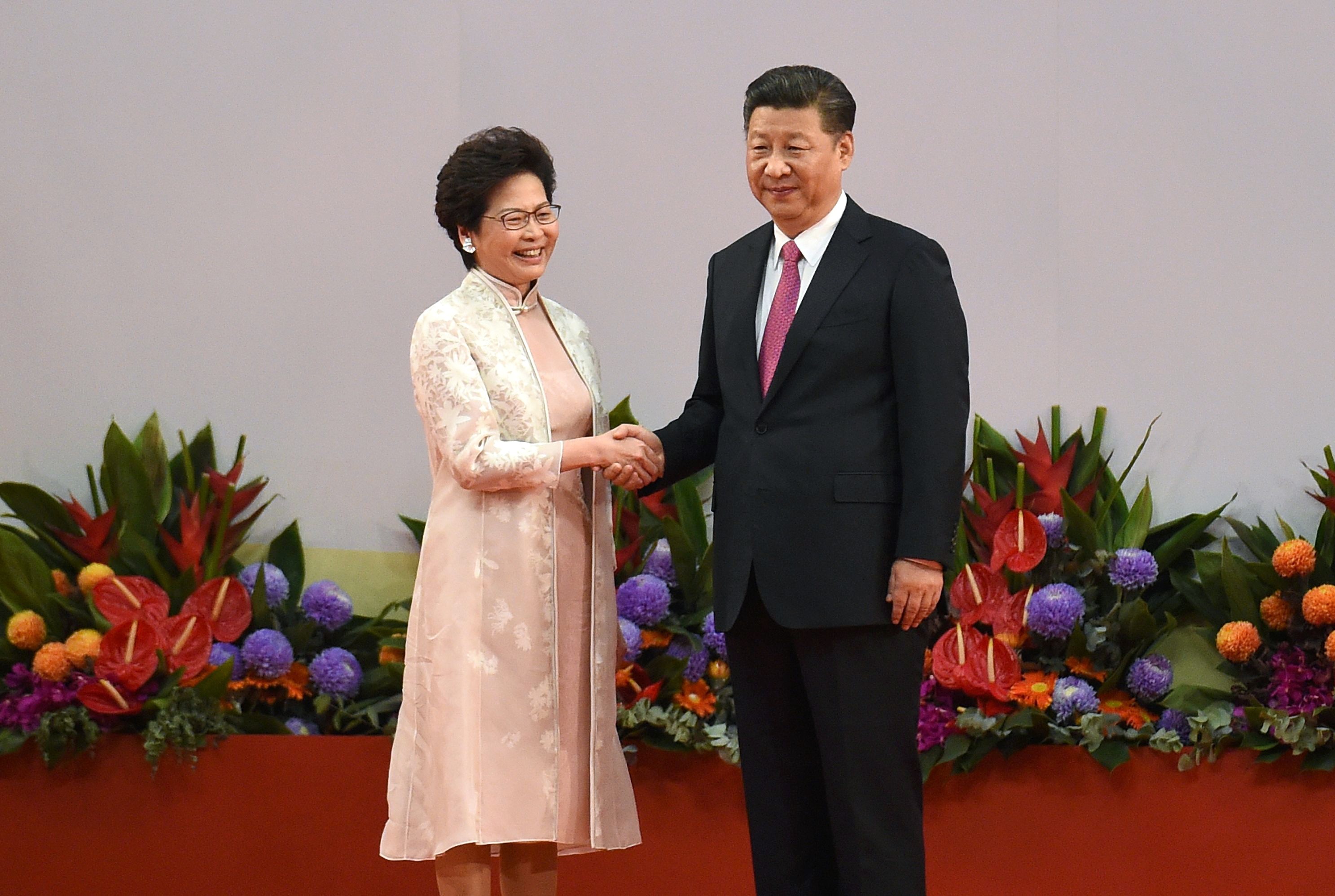 Newly minted Hong Kong Chief Executive Carrie Lam shakes hands with Chinese President Xi Jinping. AFP PHOTO / Anthony WALLACE