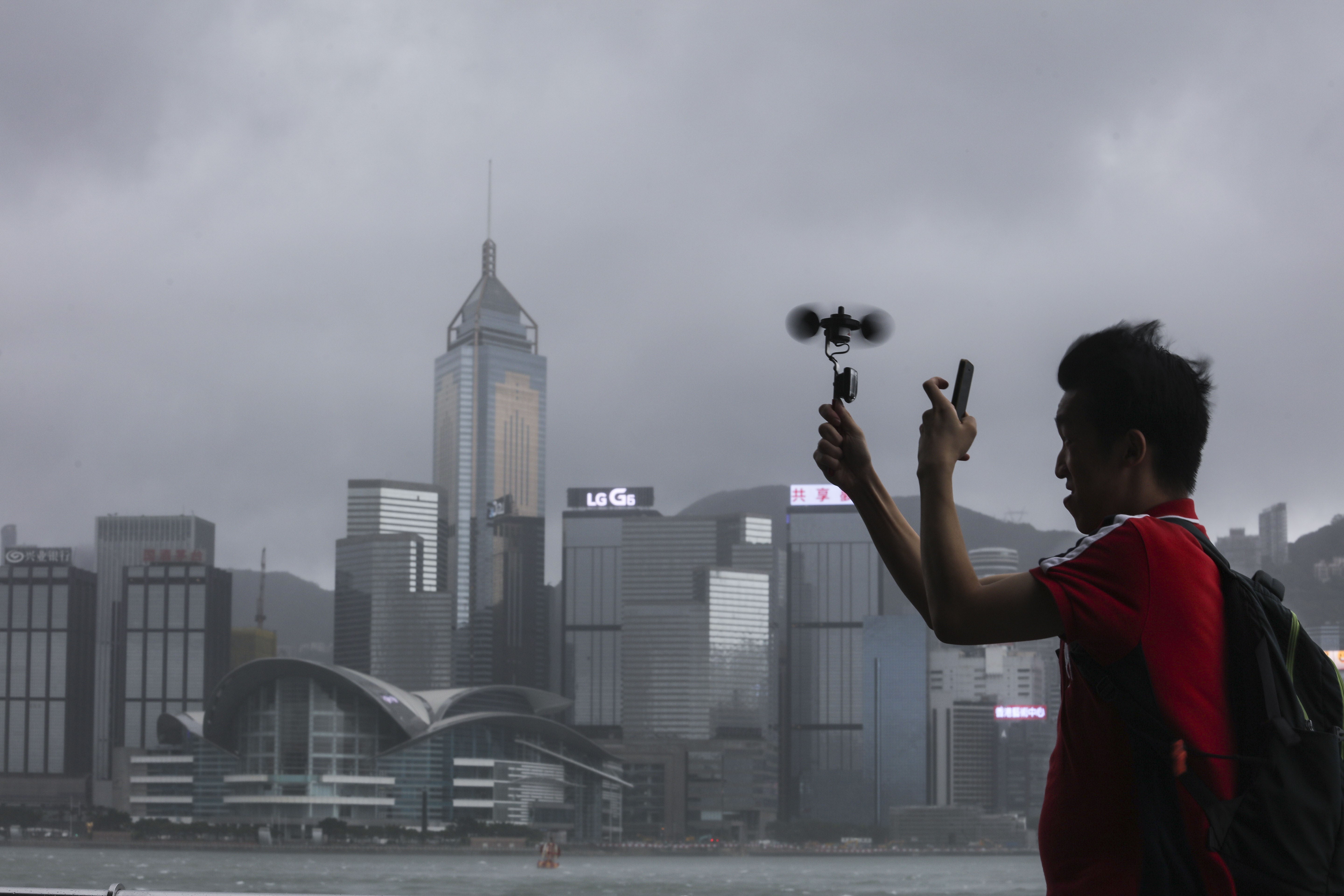 A man checks the wind speed in Tsim Sha Tsui as Pakhar hits Hong Kong on August 27. Photo: Felix Wong