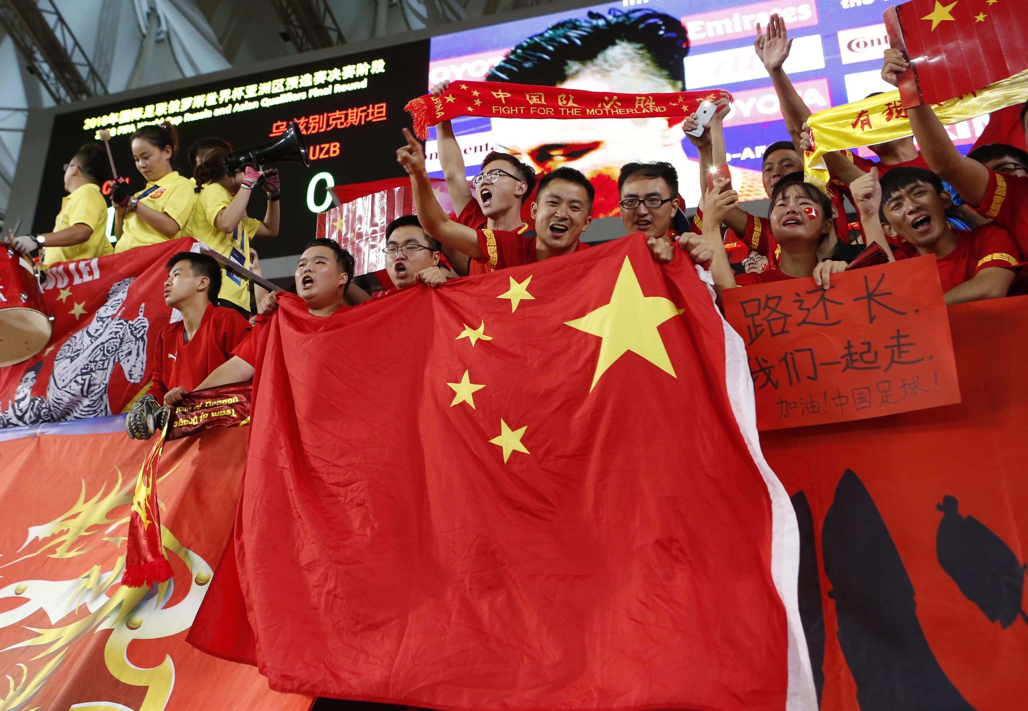 Chinese fans wave the national flag against Uzbekistan. Photo: AFP
