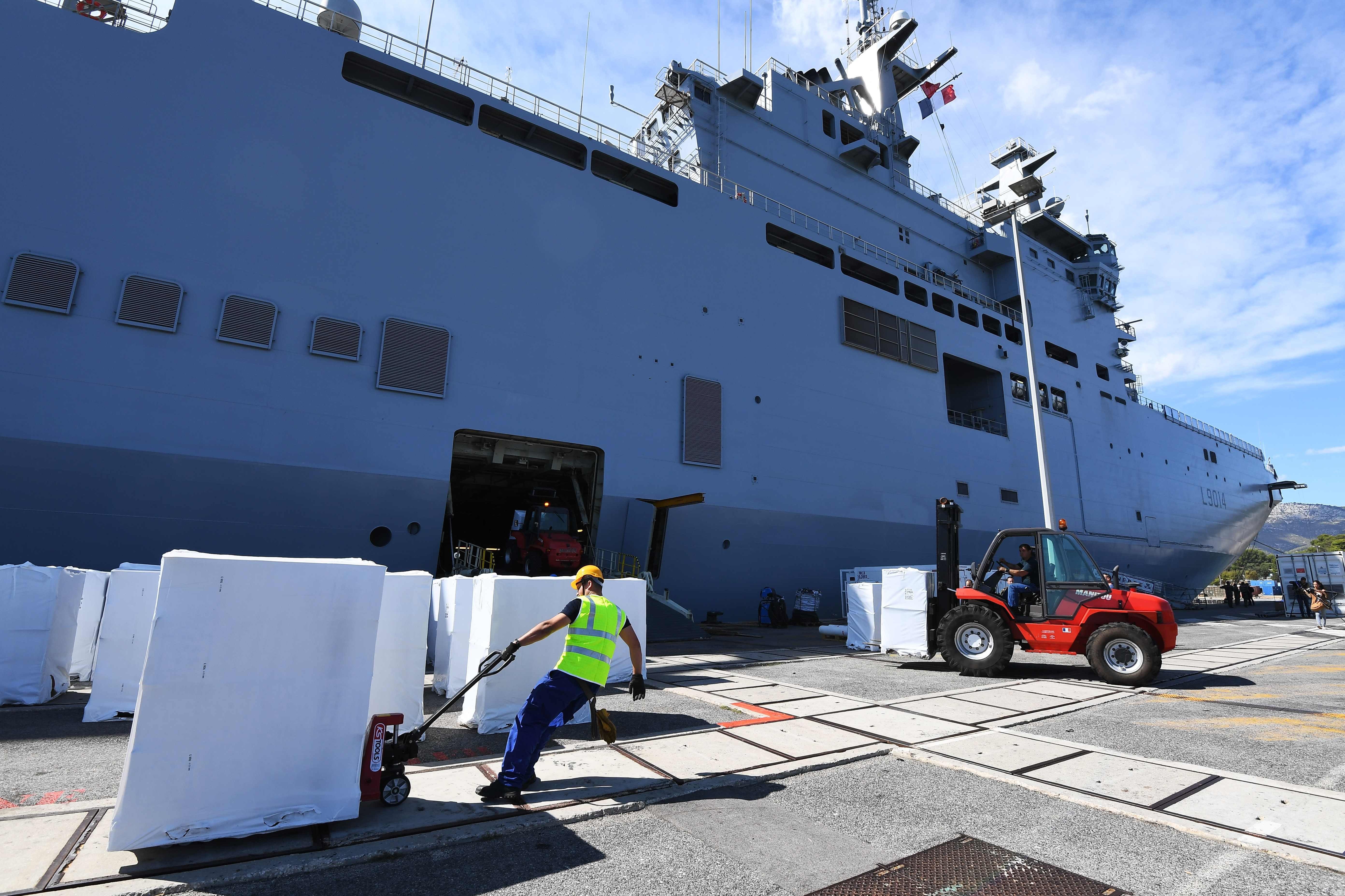 Members of the French navy load reconstruction and assistance equipment on the BPC Tonnerre, at the naval base in Toulon on September 11, 2017, on the eve of its departure to the French Caribbean islands to reinforce the rescue after the passage of Hurricane Irma. Britain, France, the Netherlands and the United States have ramped up relief efforts for their territories in the Caribbean. Photo: AFP