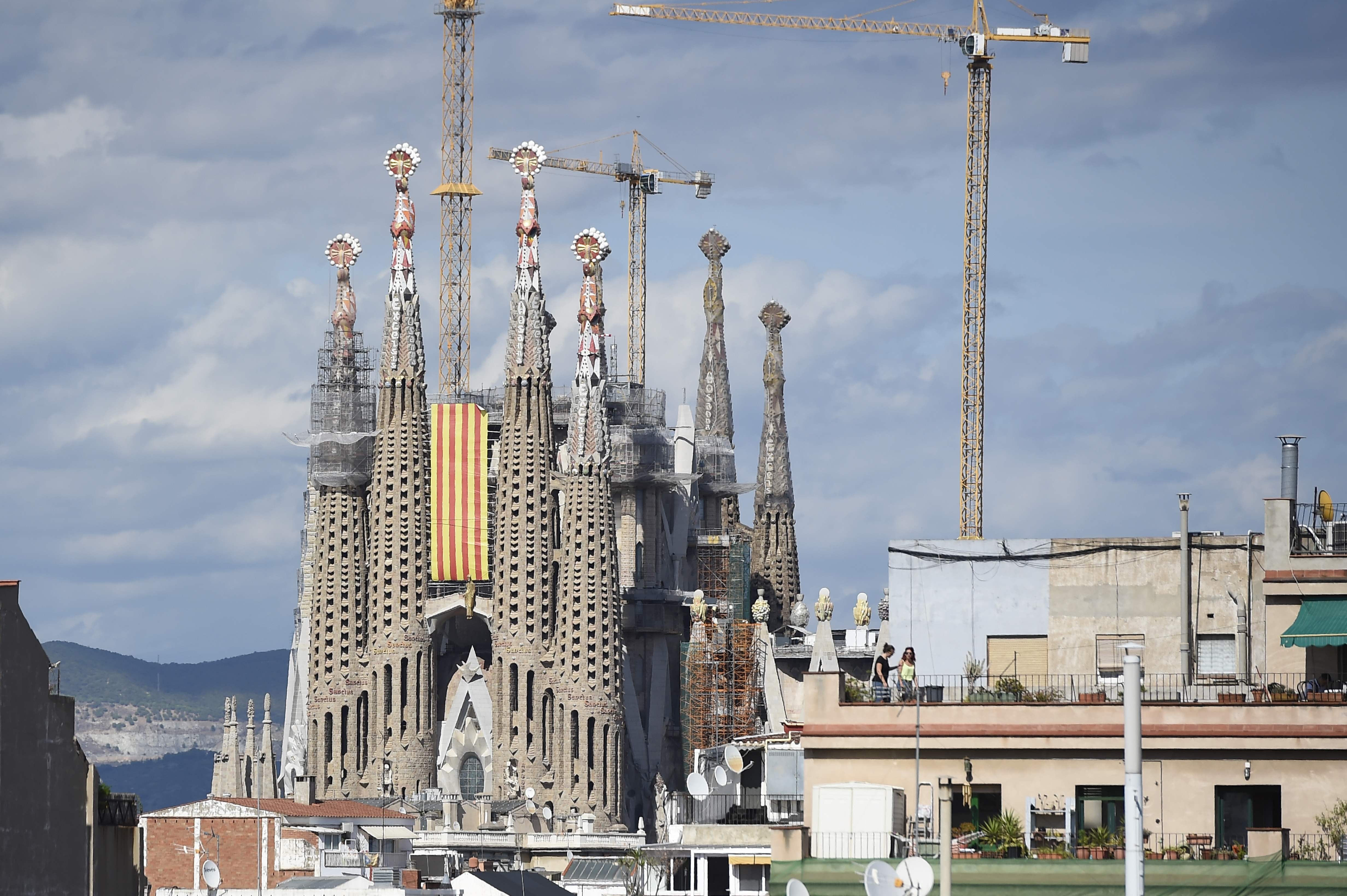 A Senyera flag (Catalan flag) hangs from the “Sagrada Familia” (Holy Family) basilica in Barcelona during the National Day of Catalonia, the “Diada.” The site was evacuated on Tuesday, September 12, because of an anti-terror operation. Photo: AFP