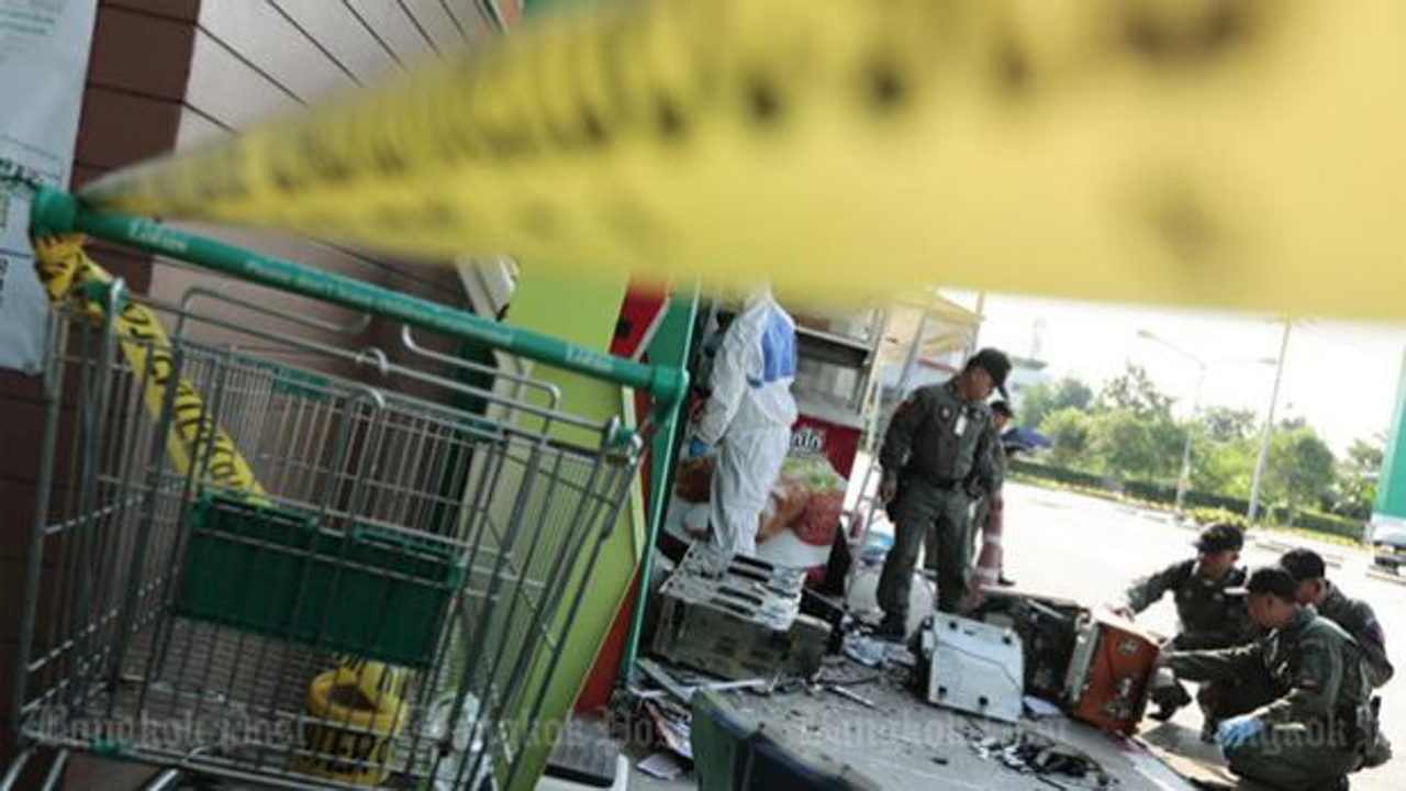 Explosive Ordnance Disposal officers inspect the bomb scene and shattered ATM outside the Tesco Lotus branch in Prawet, Bangkok, on Wednesday morning. Photo: Patipat Janthong/Bangkok Post
