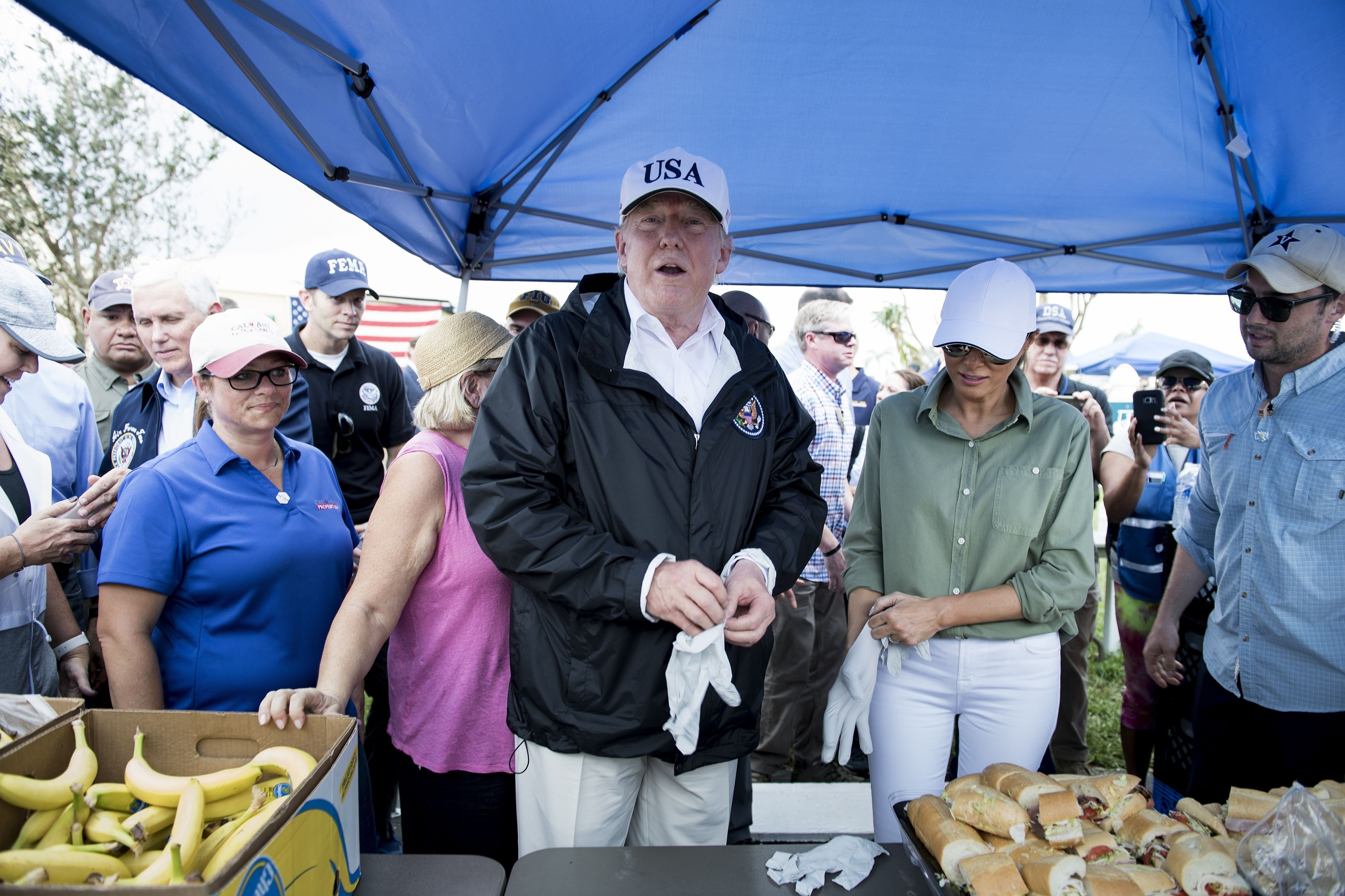 US President Donald Trump and US First Lady Melania Trump put on gloves to hand out food while touring the Naples Estates neighbourhood damaged during Hurricane Irma on September 14, 2017 in Naples, Florida. Photo: AFP