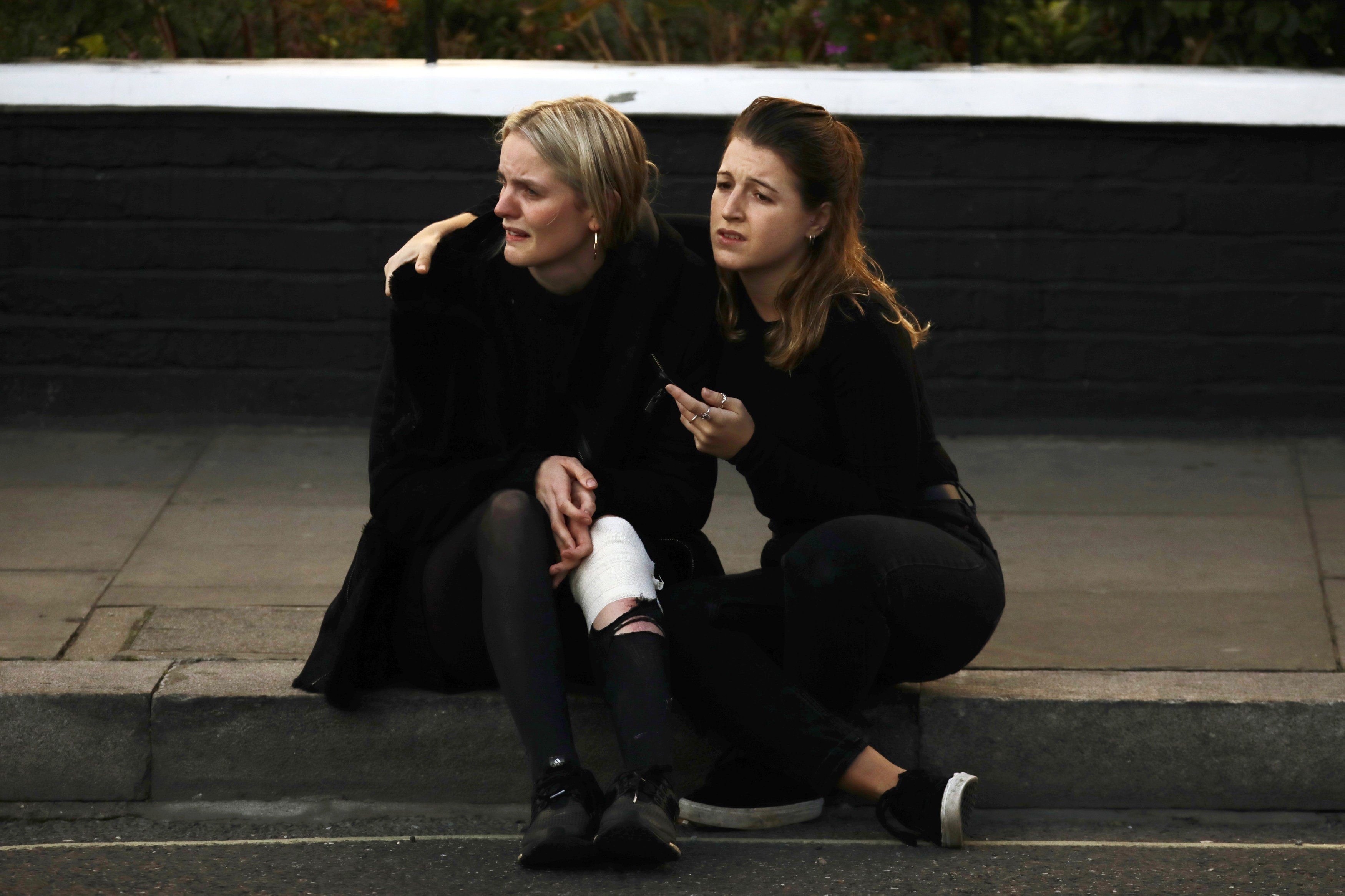 An injured woman sits and cries on the pavement outside Parsons Green station in London after a bomb was detonated on a packed commuter train. Photo: Reuters