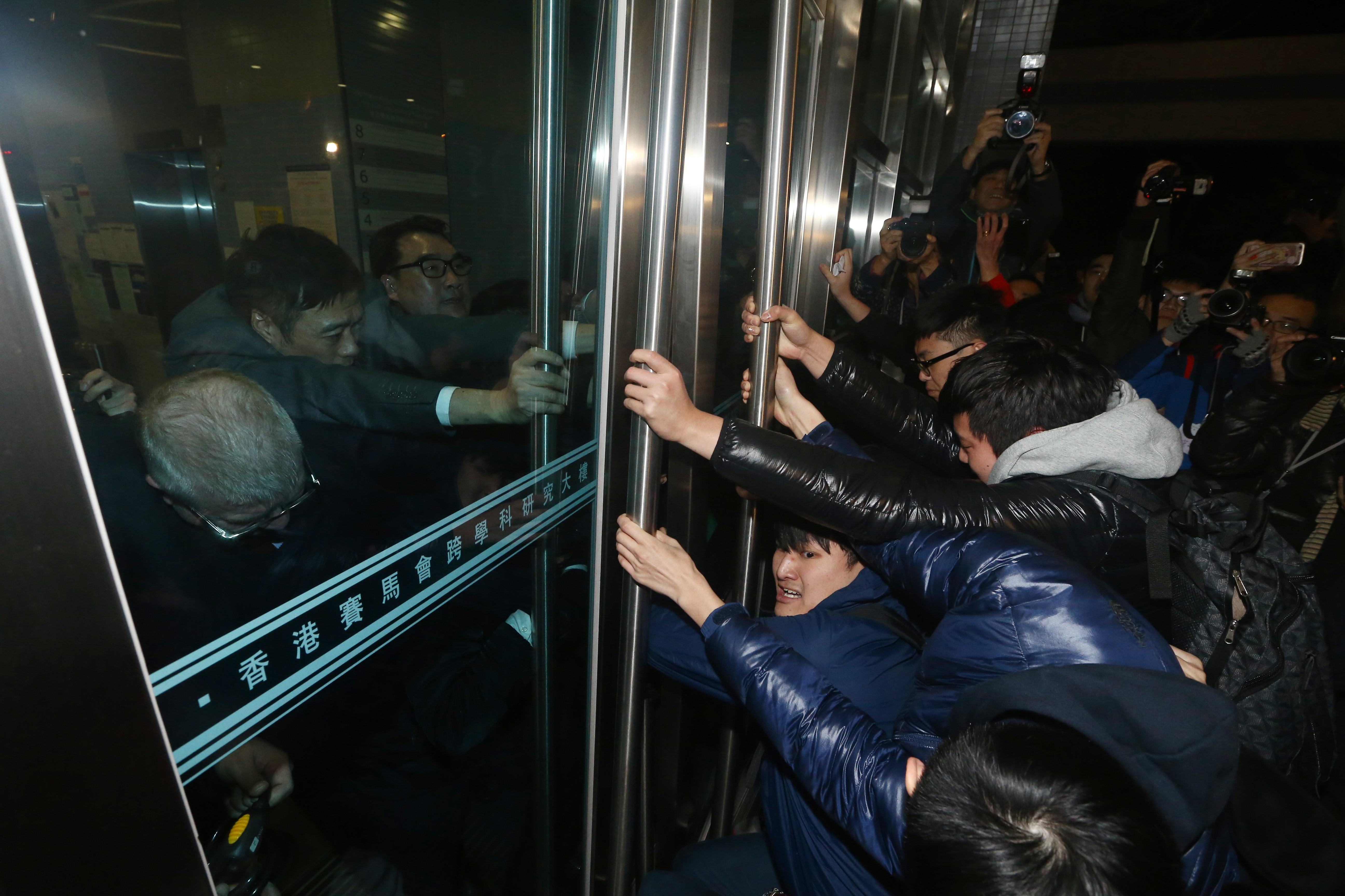 HKU students try to break into the The Hong Kong Jockey Club Building For Interdisciplinary Research on Sassoon Road in Pok Fu Lam, where the council meeting was held. Photo: Sam Tsang