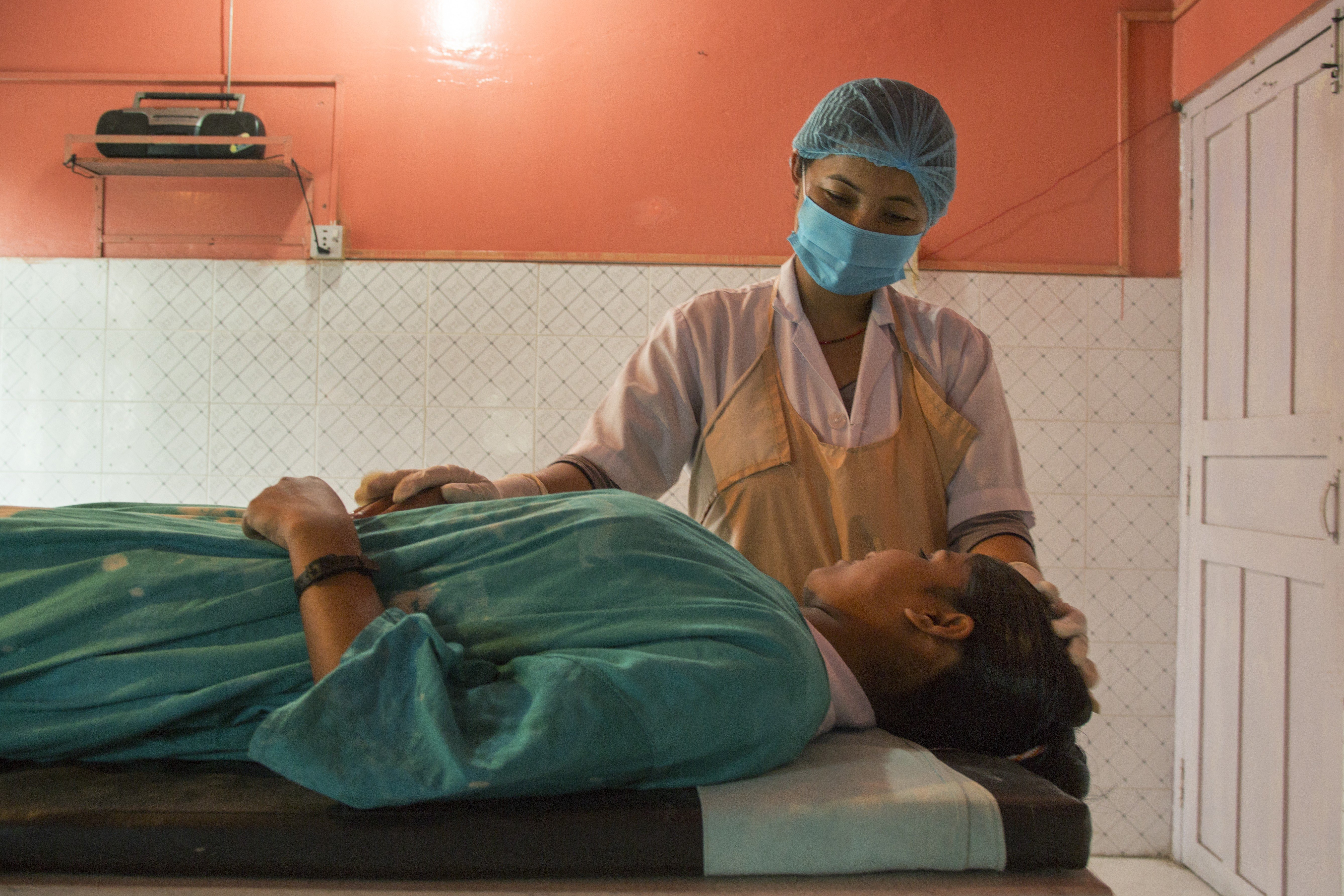 Theatre nurse Jhamaka Limbu assists in an abortion at the Family Health centre in Itari, Sansari, Nepal. According to the WTO, approximately 68,000 women die annually due to complications of unsafe abortion; between 2 and 7 million women each year sustain long-term damage or disease. Photo: IPPF / Tom Pilston