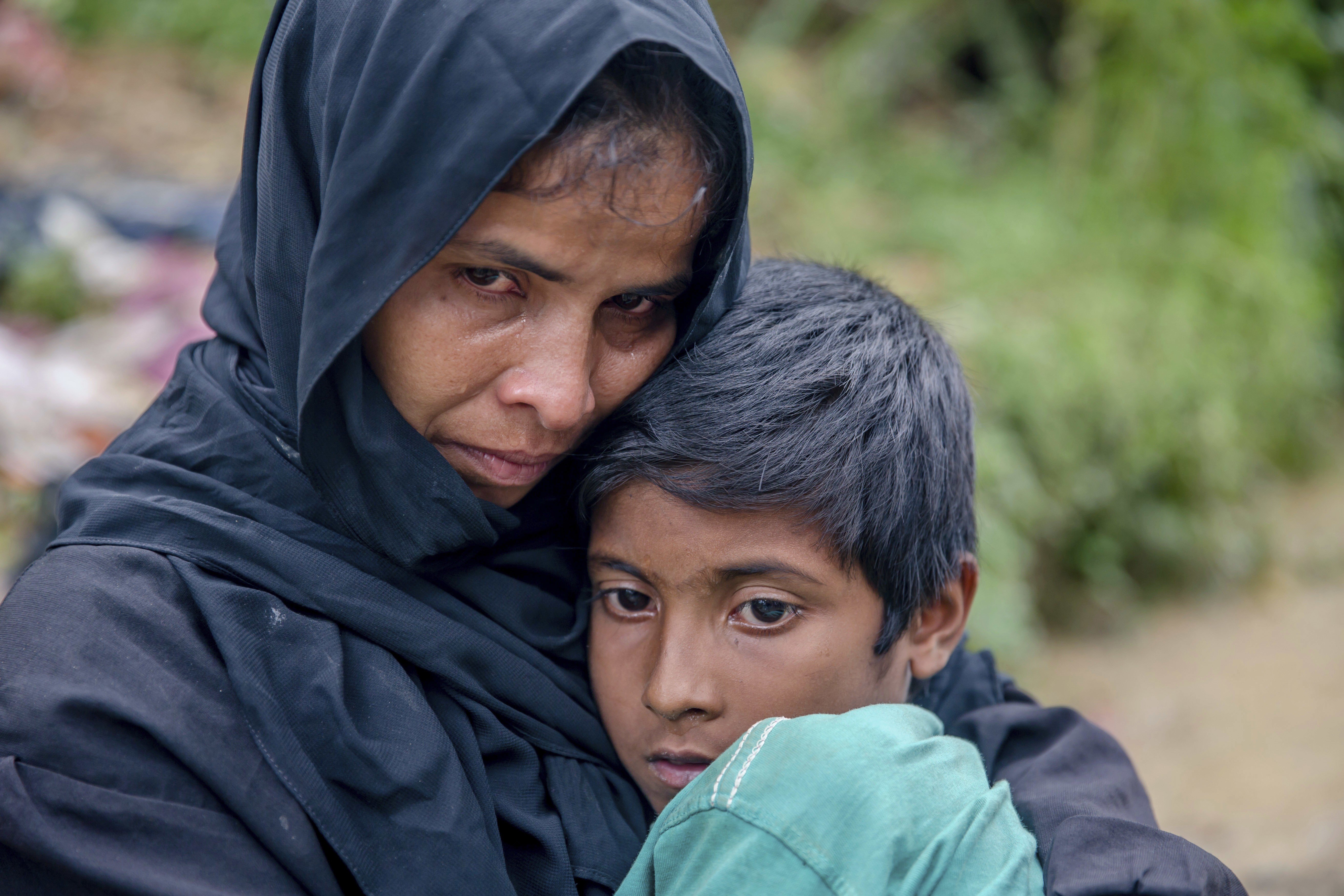 A Rohingya Muslim waits for help to transport her sick son to a nearby clinic in Taiy Khali, Bangladesh, on Wednesday. Photo: AP