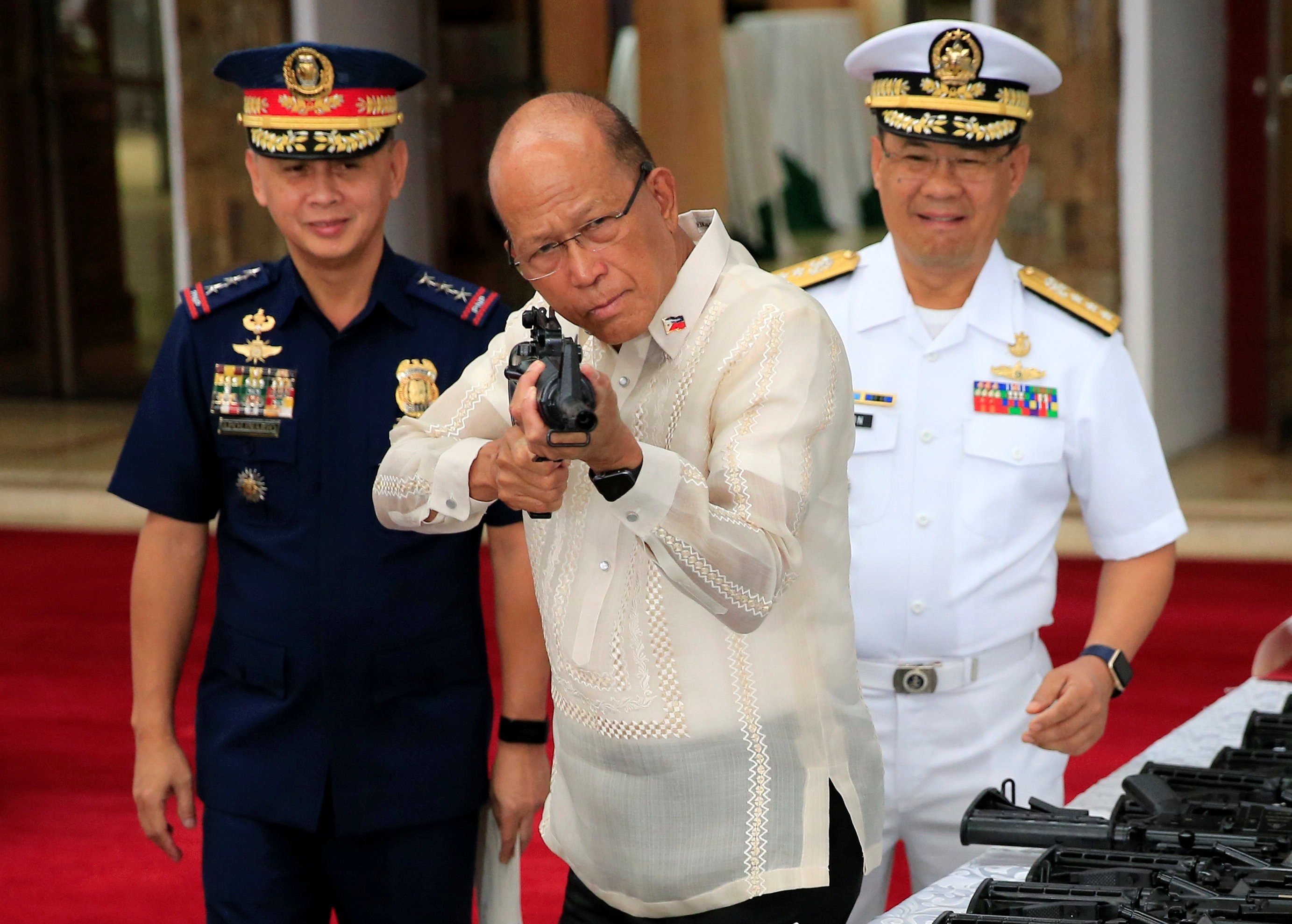 Philippine Defence Secretary Delfin Lorenzana inspects a rifle given to the Philippines by China. Photo: Reuters