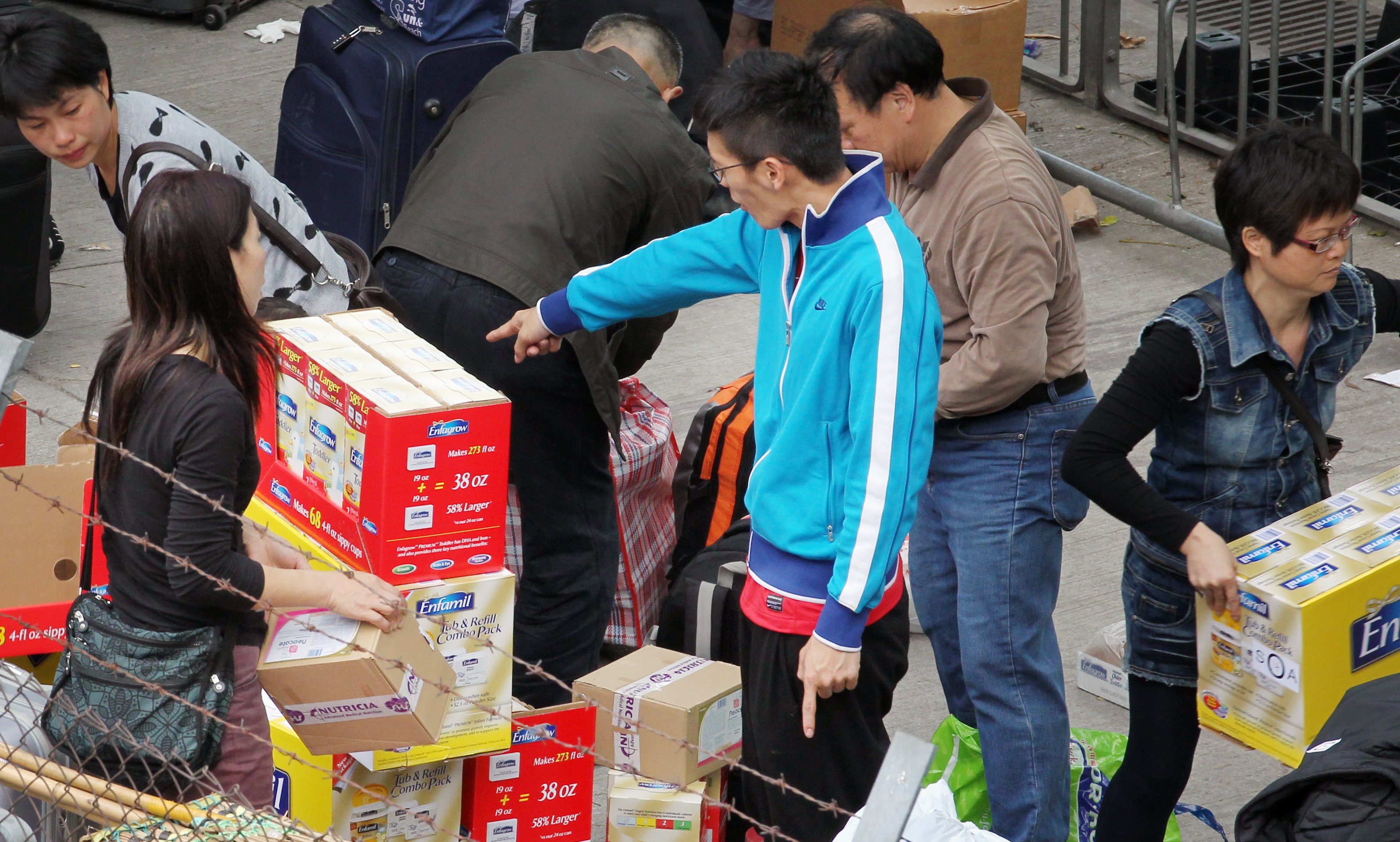 Traders handling luggage outside Sheung Shui station in 2013. Photo: Nora Tam