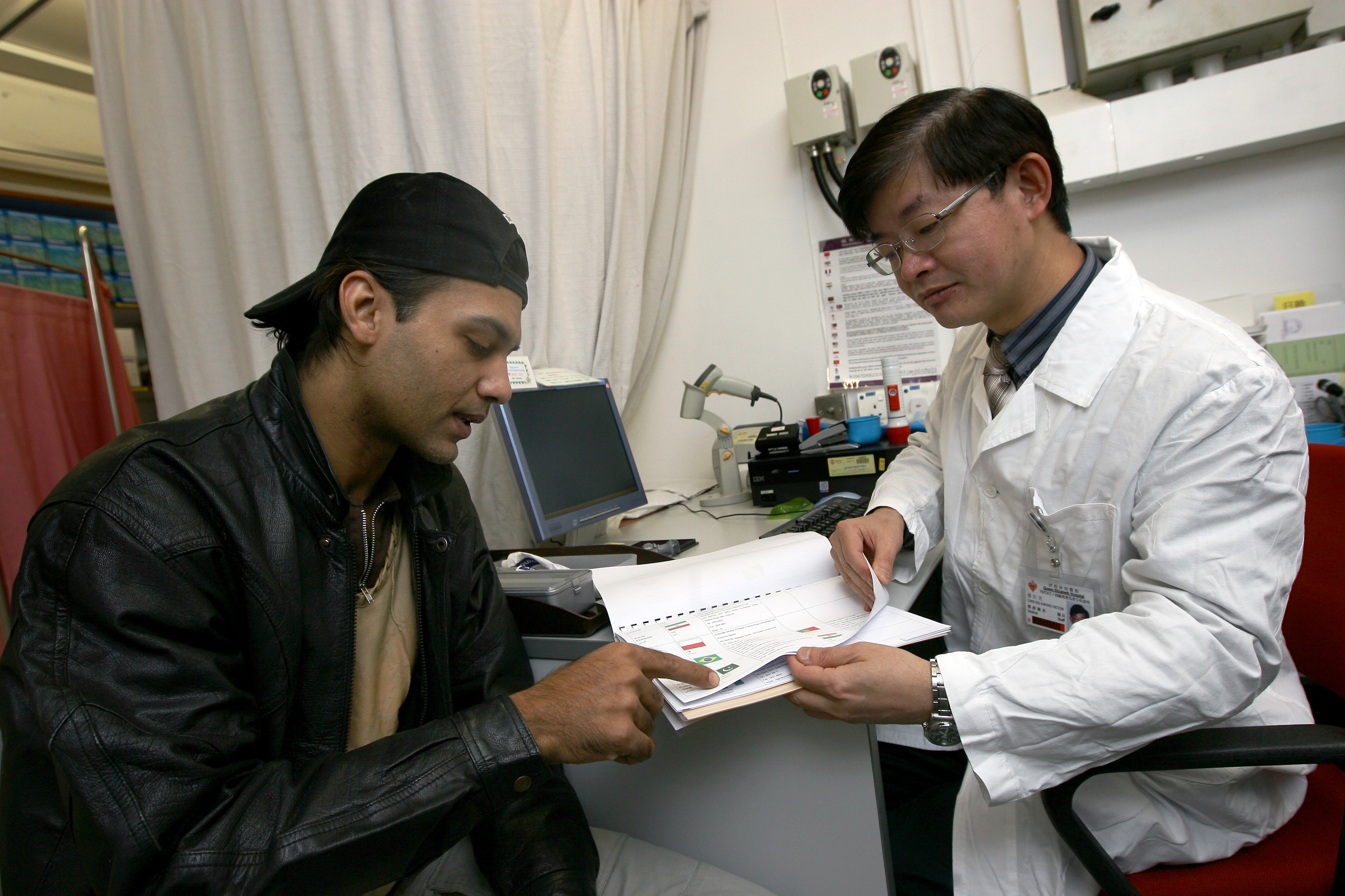 Doctor Victor Choi Sze-kwong, of the Yau Ma Tei Jockey Club General Out-patient Clinic, asks a patient to indicate his nationality so an interpretor can be provided before examination. Photo: K.Y. Cheng