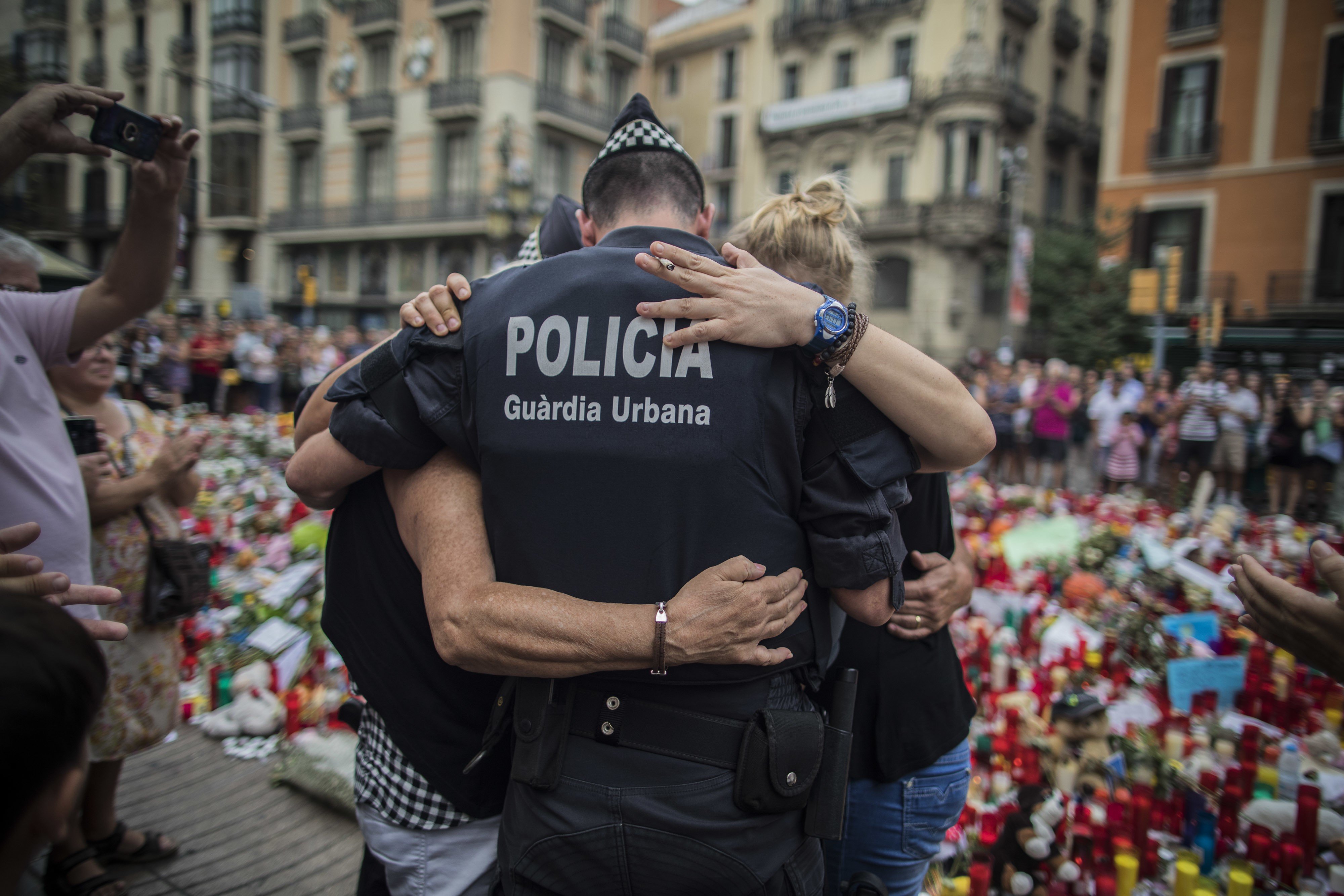 A policeman hugs a boy and his family that he helped during the terrorist attack in Las Ramblas, Barcelona. Photo: AP