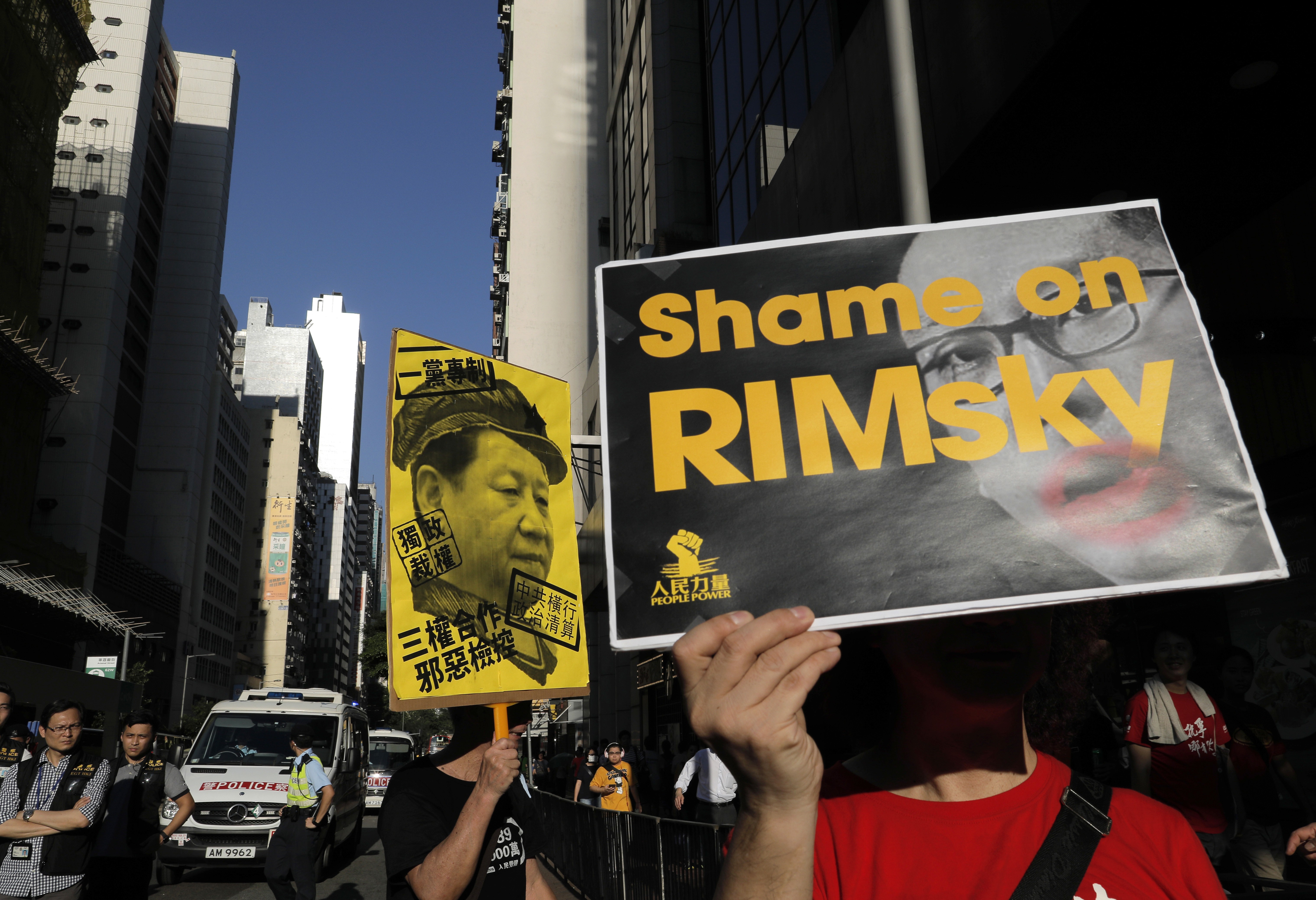 Protesters raise a placard to criticise Hong Kong Secretary for Justice Rimsky Yuen as they march in support of young democracy activists. Yuen appealed against the original “lenient” sentencing of the three activists, resulting in them receiving jail time. Photo: AP