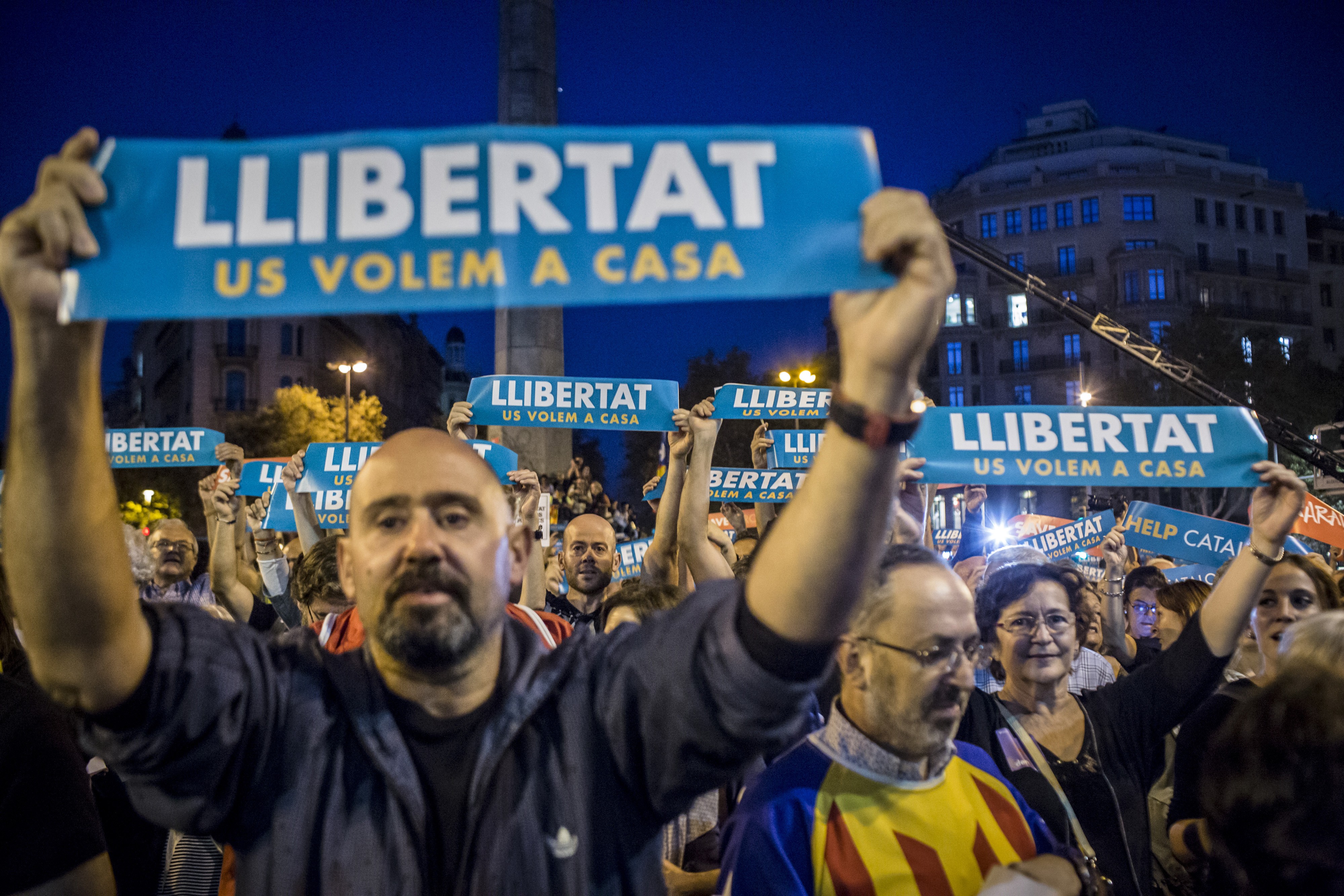 Protesters hold up banners reading “Help Catalonia” during a candlelight vigil to demand the release of imprisoned separatist leaders Jordi Sanchez, head of the Catalan National Assembly, and Jordi Cuixart, head of the Omnium Cultural association, in Barcelona, Spain, on October 17. Photo: Bloomberg