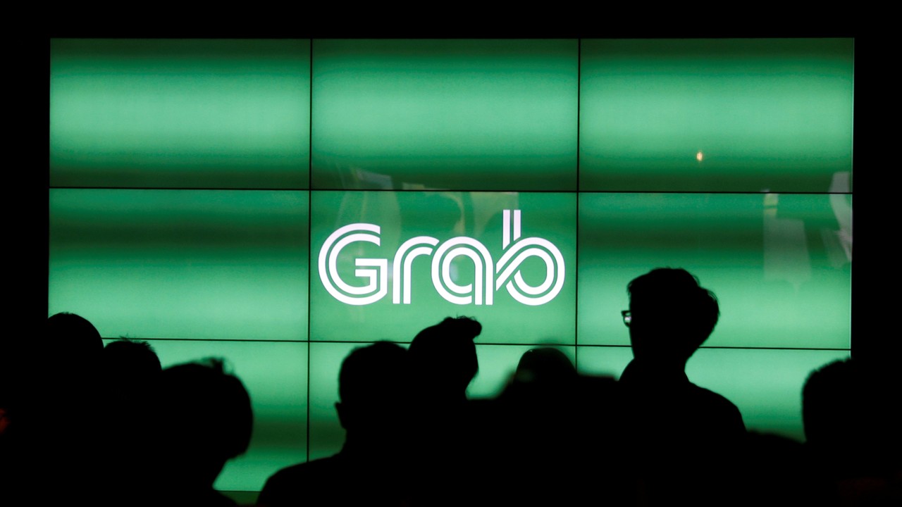 FPeople wait for the start of ride-hailing company Grab's fifth anniversary news conference in Singapore. Photo: REUTERS/Edgar Su