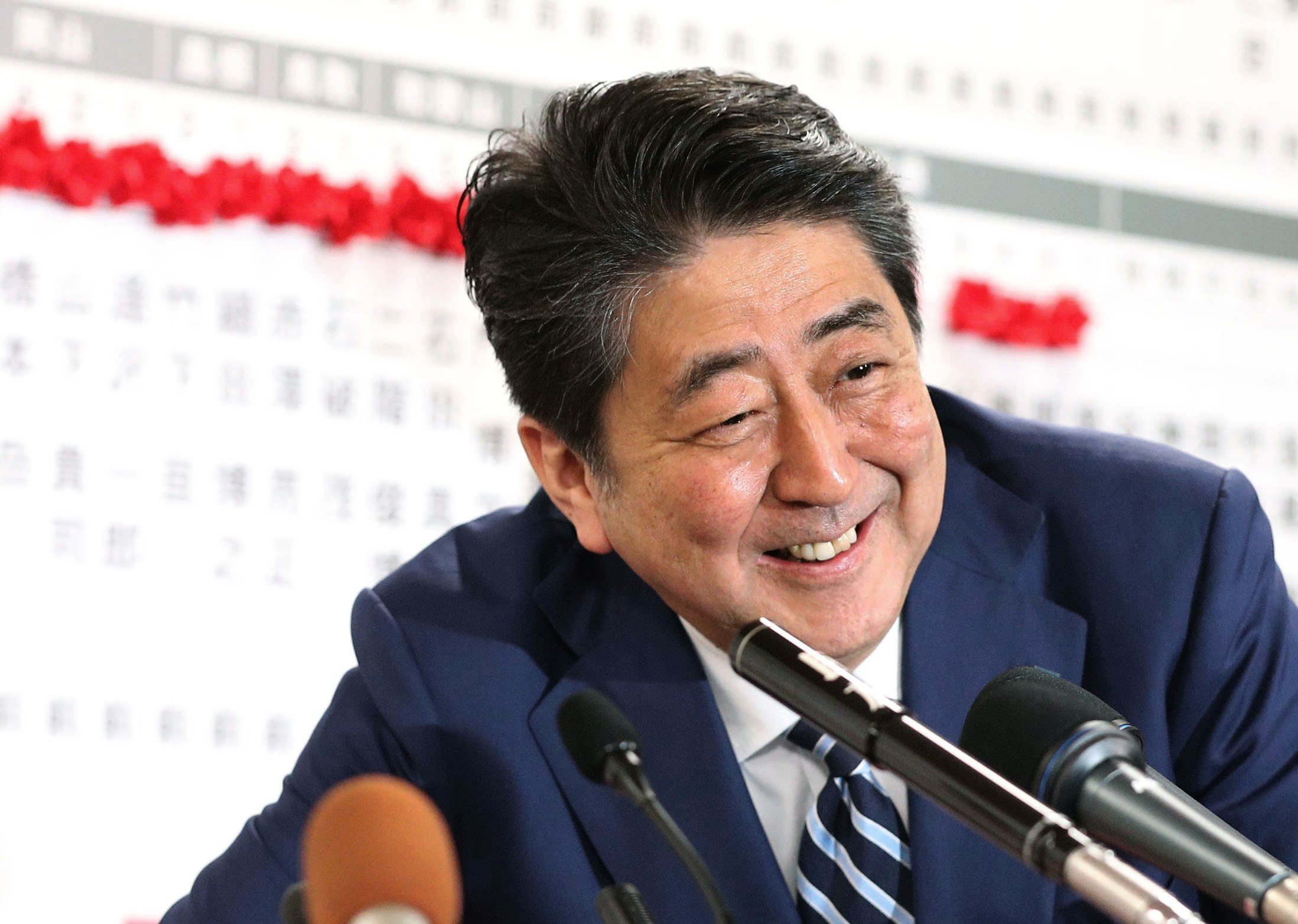 Japanese Prime Minister Shinzo Abe smiles at the Liberal Democratic Party's headquarters in Tokyo on Sunday as news of LDP candidates’ victories come in. Photo: Kyodo