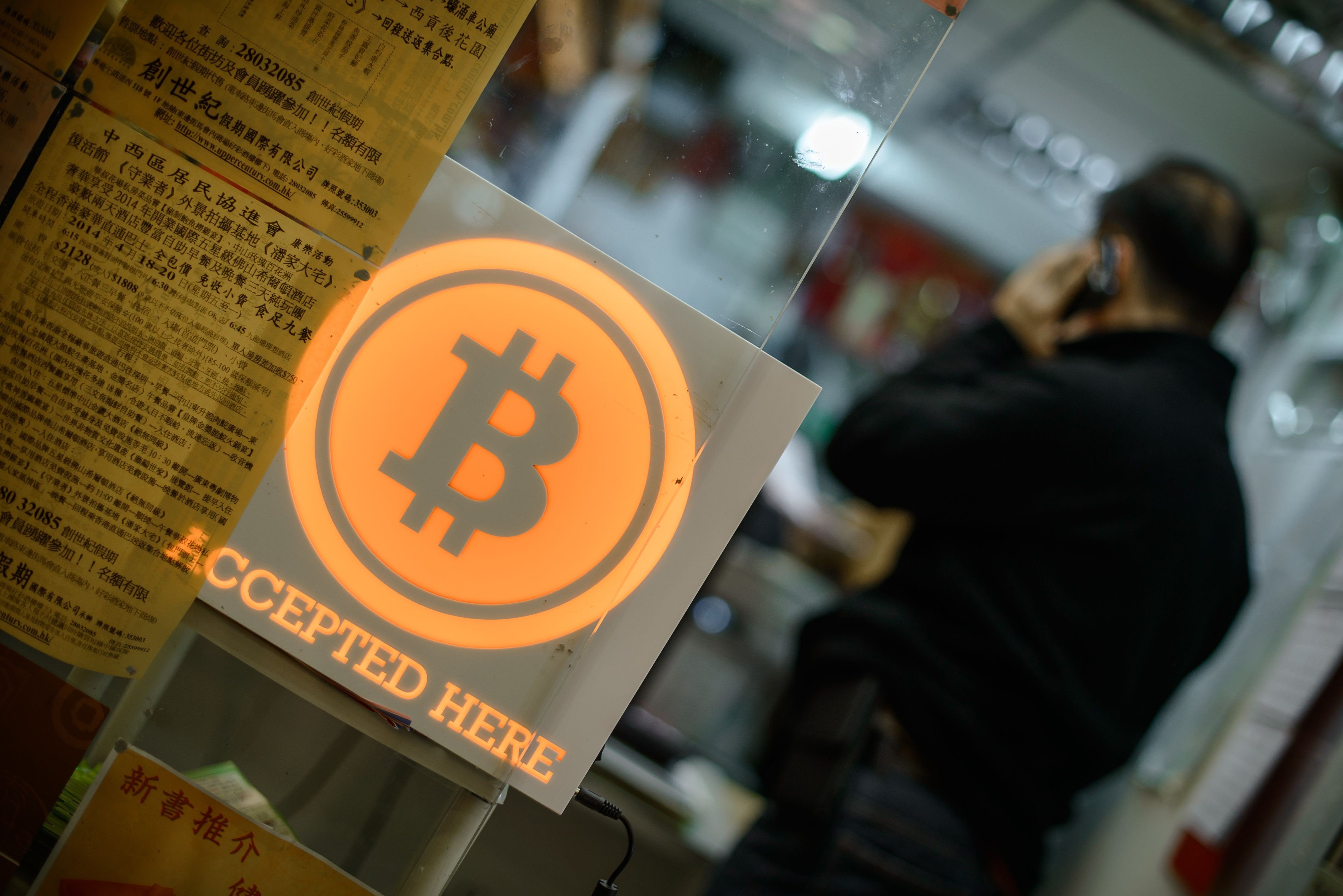 A man talks on a mobile phone during the opening ceremony of the first bitcoin retail shop in Hong Kong in 2014. Photo: AFP