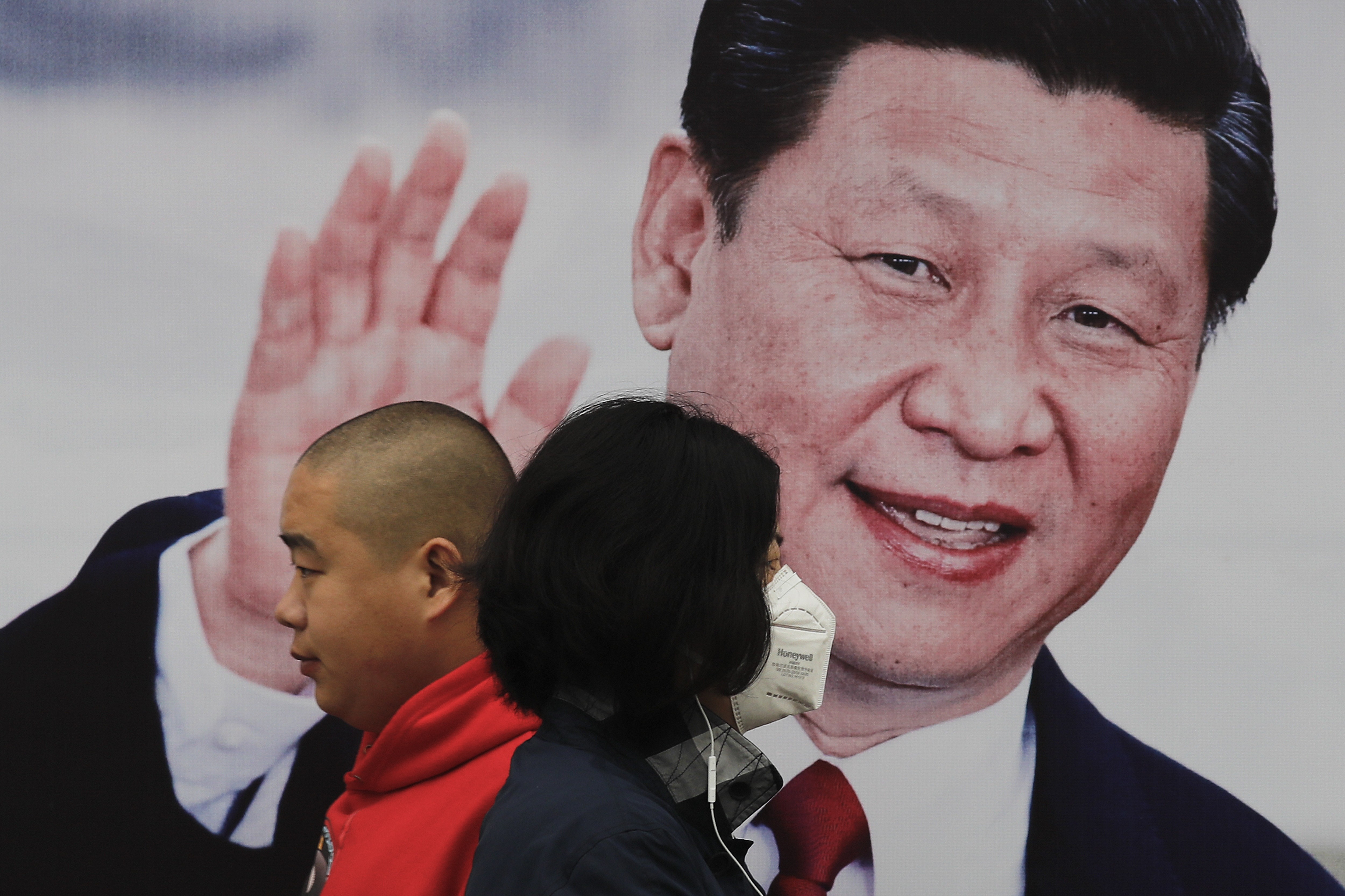 Pedestrians walk past a poster of Chinese President Xi Jinping on a street in Beijing on October 26. China's ruling Communist Party has praised Xi as a Marxist thinker, adding to the propaganda promoting Xi’s personal image as he begins his second five-year term as leader. Photo: AP