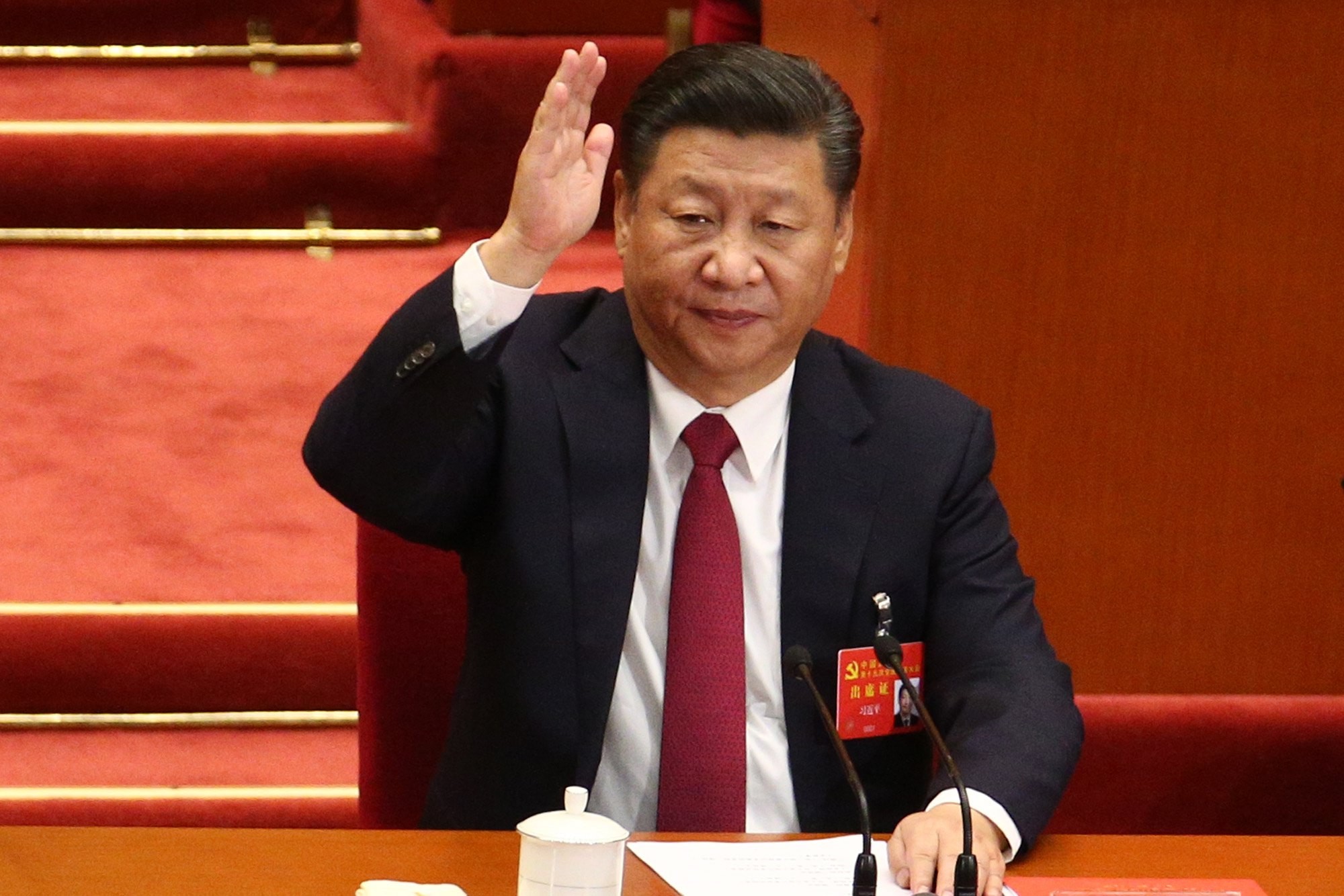 Chinese President and General Secretary of the Communist Party of China Xi Jinping raises hand to take a vote during the closing ceremony of the 19th National Congress of the Communist Party of China. Photo: EPA
