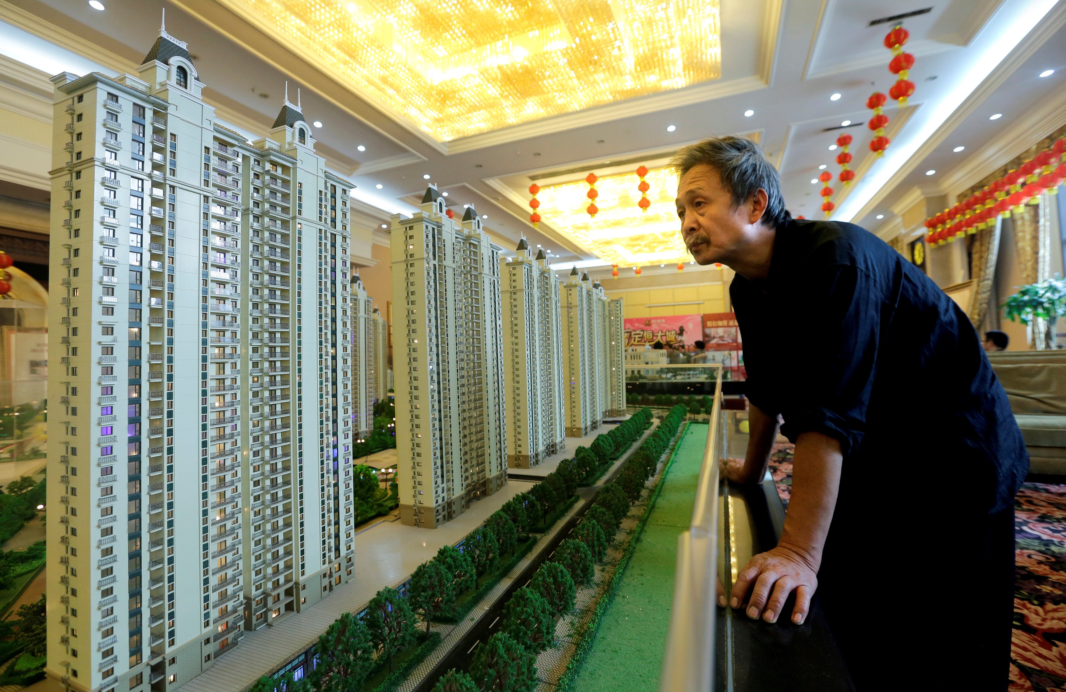 A visitor looks at a model of a new apartment complex at a showroom of Evergrande Real Estate Group. The company is planning to list its property arm on the Shenzhen stock exchange. Photo: Reuters