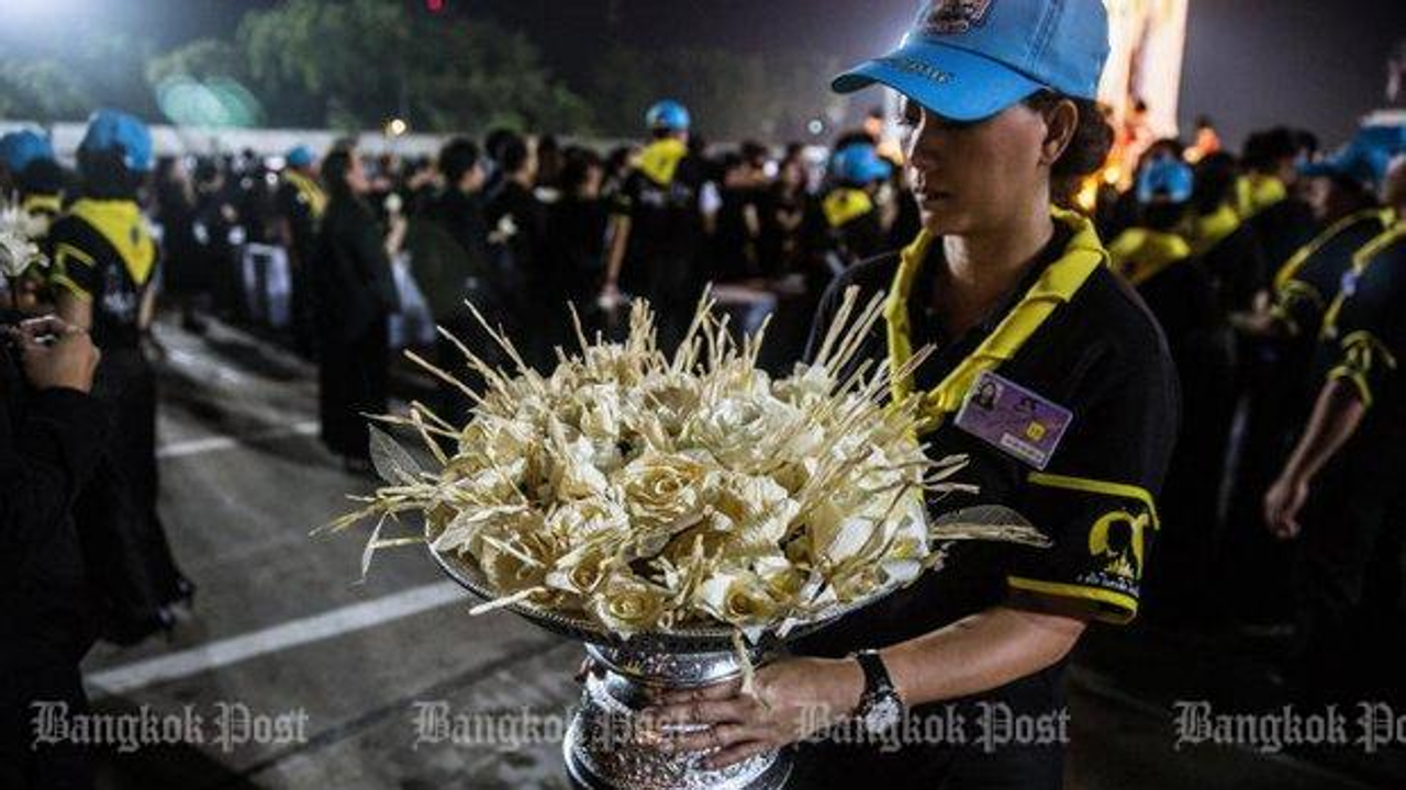 A volunteer holds dok mai chan used to mark the royal cremation ceremony. Two provincial governors have been transferred and denied new posts for shaming the ceremony. Photo: Bangkok Post