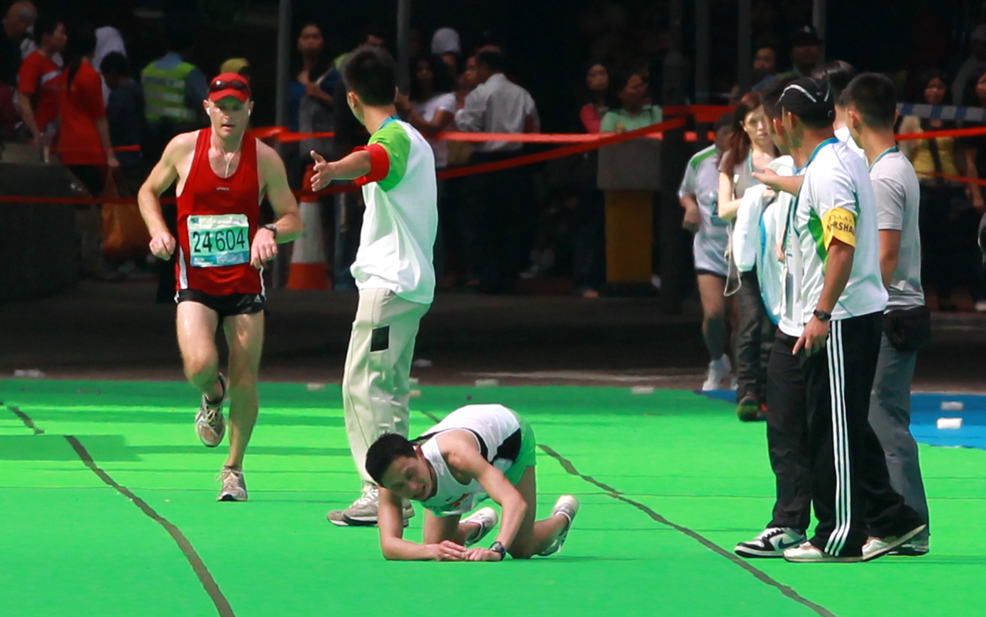 A runner collapses approaching the finish line at Victoria Park in the Hong Kong Marathon. Photo: Felix Wong