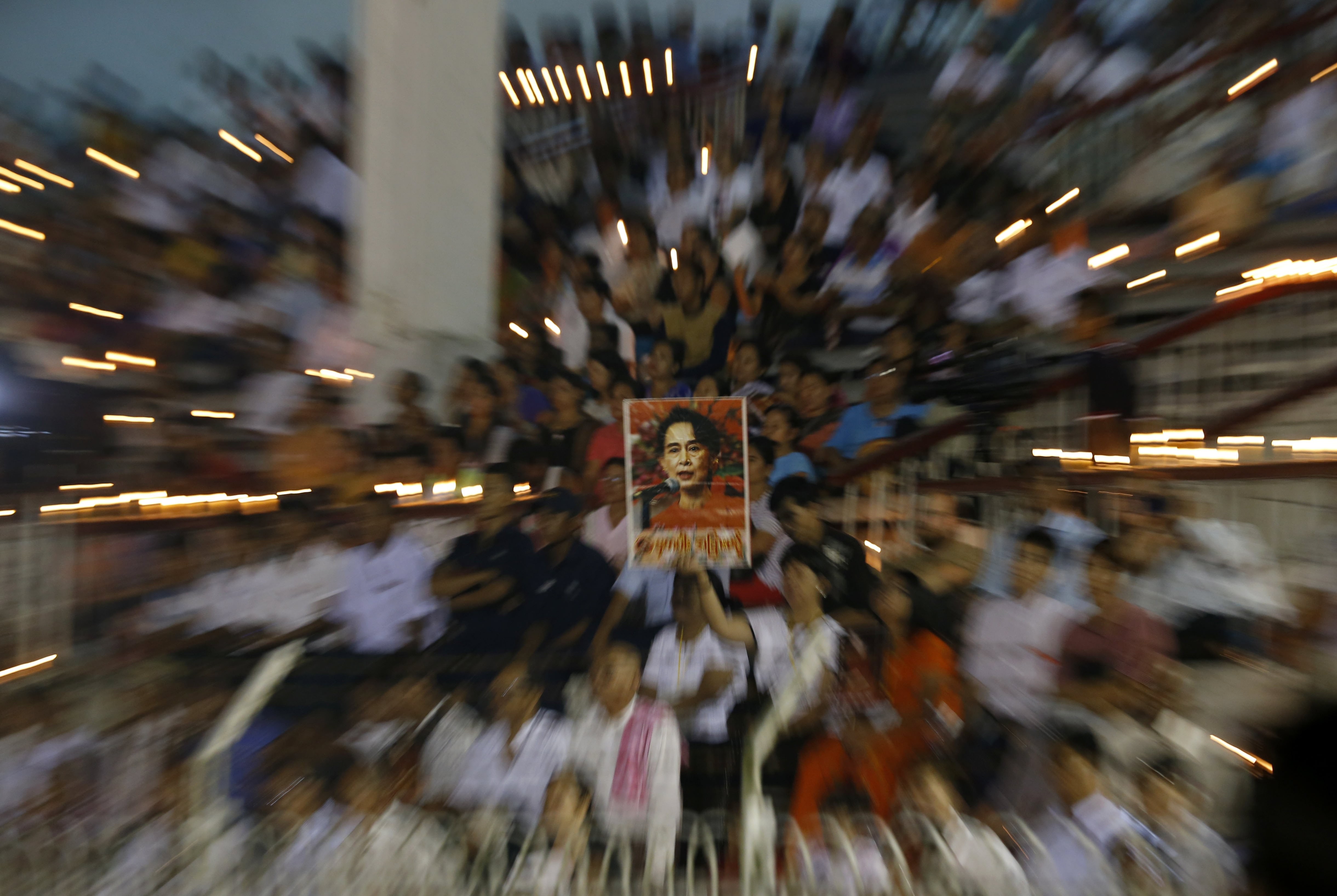People hold a portrait of Myanmar state counsellor Aung San Suu Kyi at a prayer gathering in Yangon. Photo: EPA